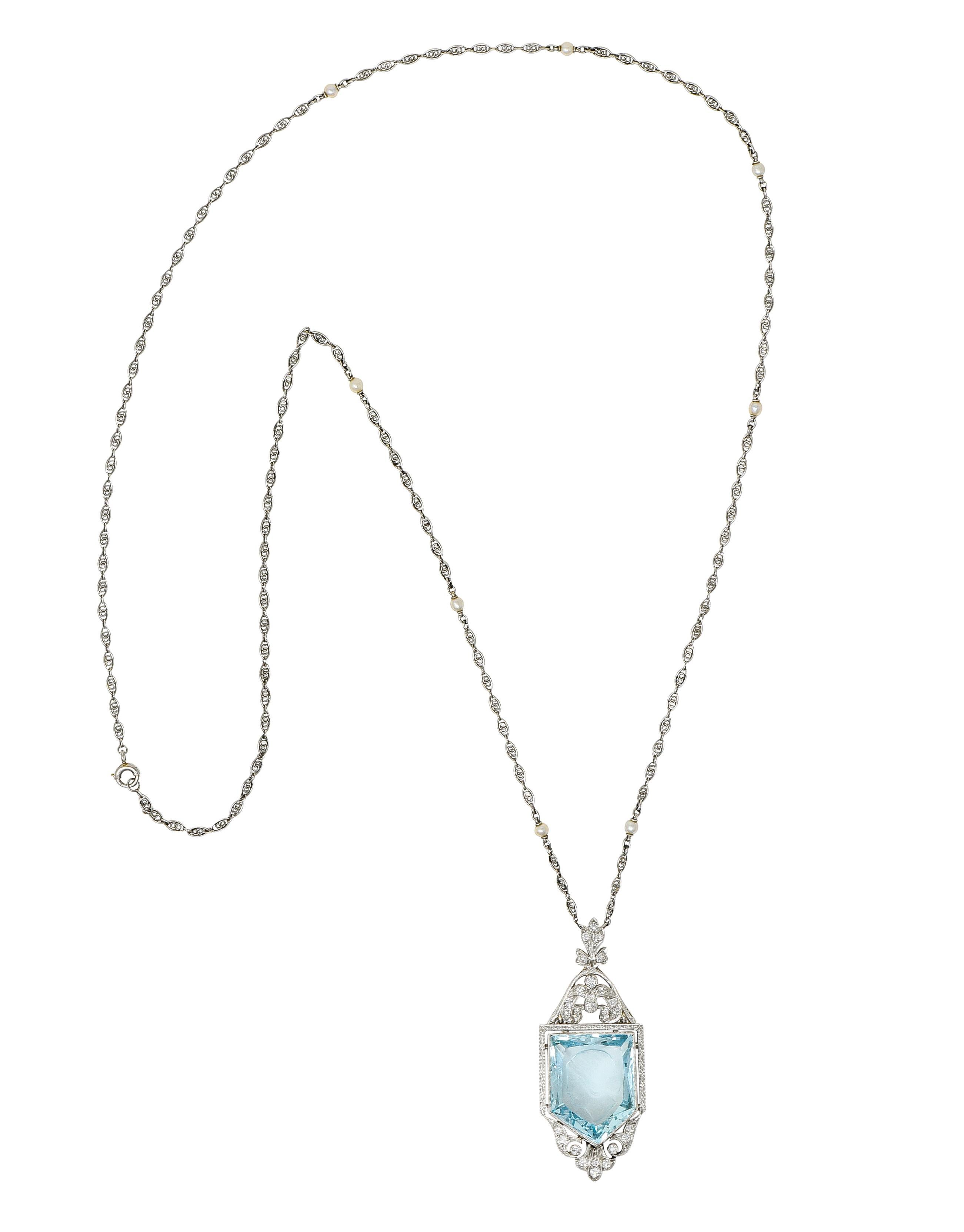 Comprised of a swirling marquise link chain with seed pearl stations - cream in body color with strong iridescence. Suspending a foliate motif pendant centering a mixed cut aquamarine weighing approximately 13.85 carats. Transparent light blue and