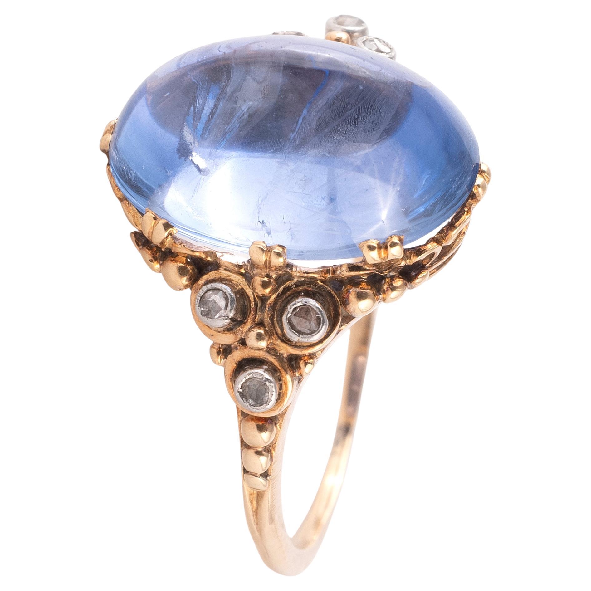 Ring aus antikem Roségold. Der Ring ist mit einem ungeheizten Saphir im Cabochon-Schliff (ca. 14,80 x 9,65 x 8,04 mm) von ca. 9 Karat sowie sechs kleinen Diamanten im Rosenschliff besetzt. Der Ring ist in gutem Zustand.

Ring Größe 8 1/2
Gewicht:
