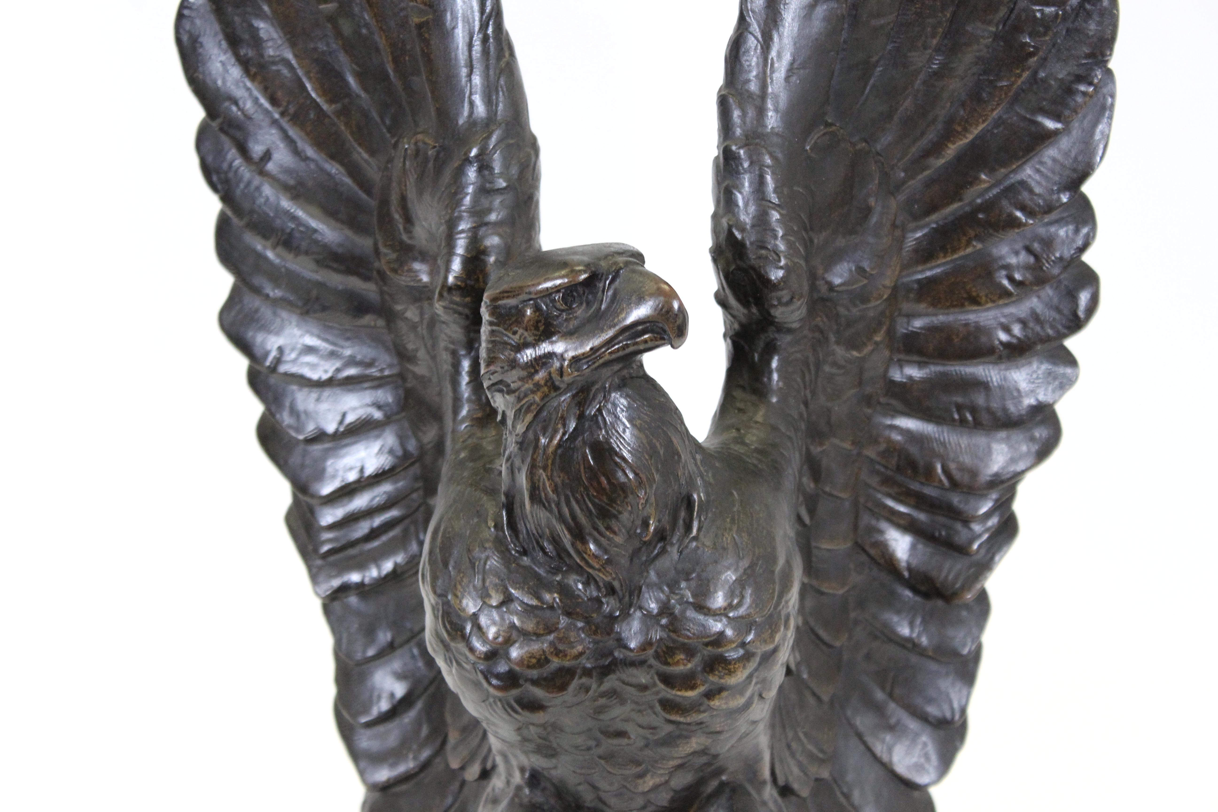 Belle Époque Animalier cast heavy bronze sculpture of an eagle with raised spread wings, mounted on a narrow stepped ebonized base. The piece was made by a German-American sculptor likely during the late 19th-early 20th century and is in remarkable