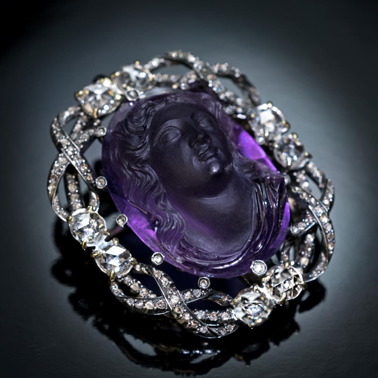 Circa 1885

This very rare antique Belle Epoque amethyst cameo brooch / pendant boasts a beautiful neoclassical portrait of a woman carved in high relief with unparalleled precision and encompassed by a rich and chunky frame of rose cut