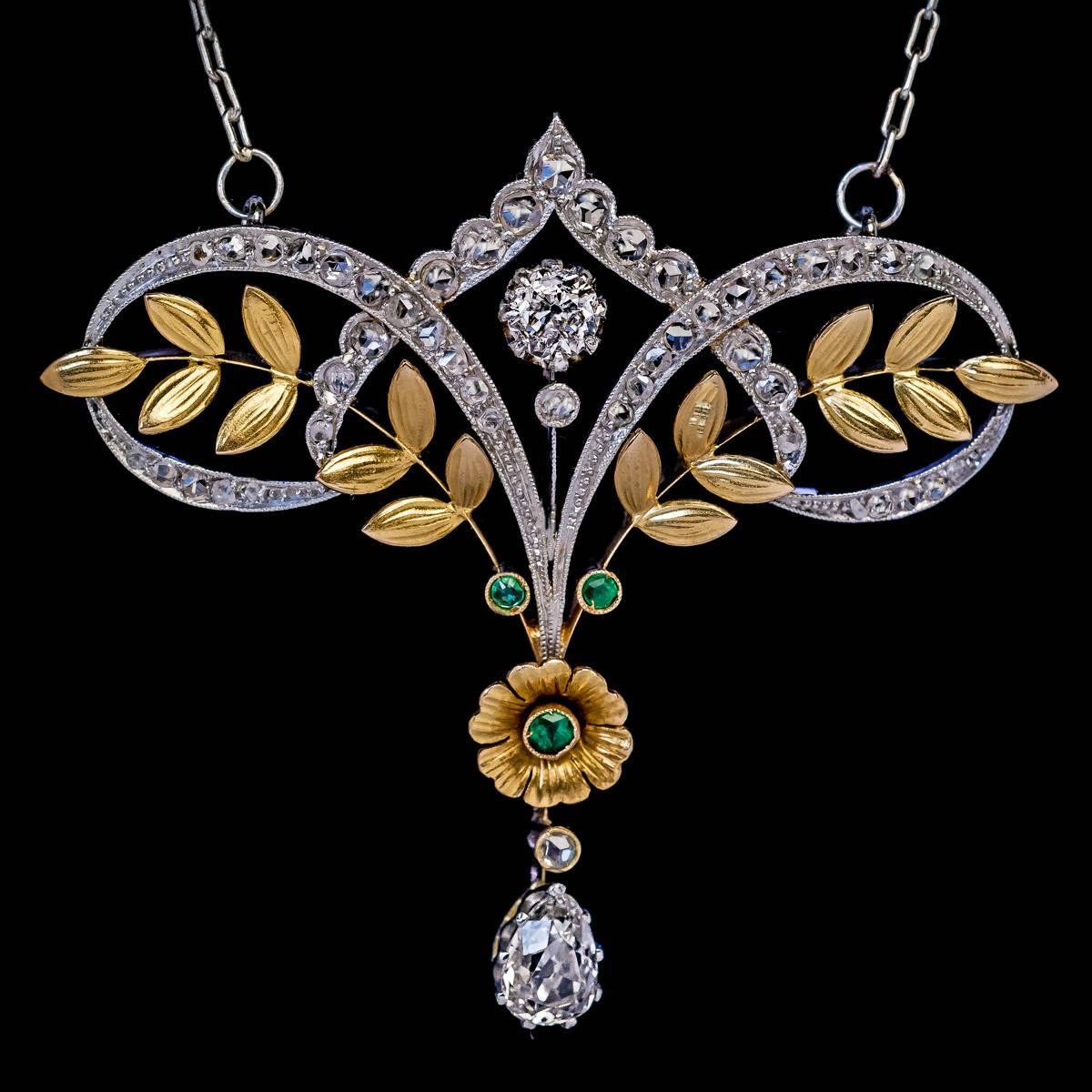 Circa 1910

An antique Edwardian era elegant garland-motif necklace is handcrafted in platinum and 18K gold. The necklace is embellished with brilliant and rose cut diamonds, and three small emeralds.

The drop shaped diamond measures 6.3 x 4.5 x