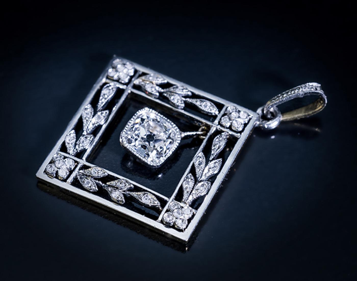 Austria, Vienna, circa 1905

This elegant antique garland motif pendant from the Edwardian era is crafted in platinum over 14K gold. The pendant features a sparkling old cushion cut diamond (approximately 0.86 ct, H color, VS1 clarity) set in a