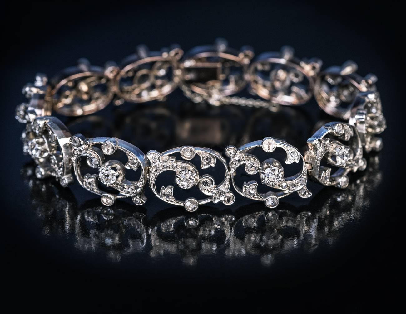 Etwa 1890er Jahre
Ein antikes französisches Armband mit durchbrochenem Blumenmotiv wurde in feiner Handarbeit aus 18-karätigem Gold mit Silberüberzug gefertigt (Vorderseite - Silber, Rückseite - Gold). Das Armband ist mit 12 Diamanten im alten