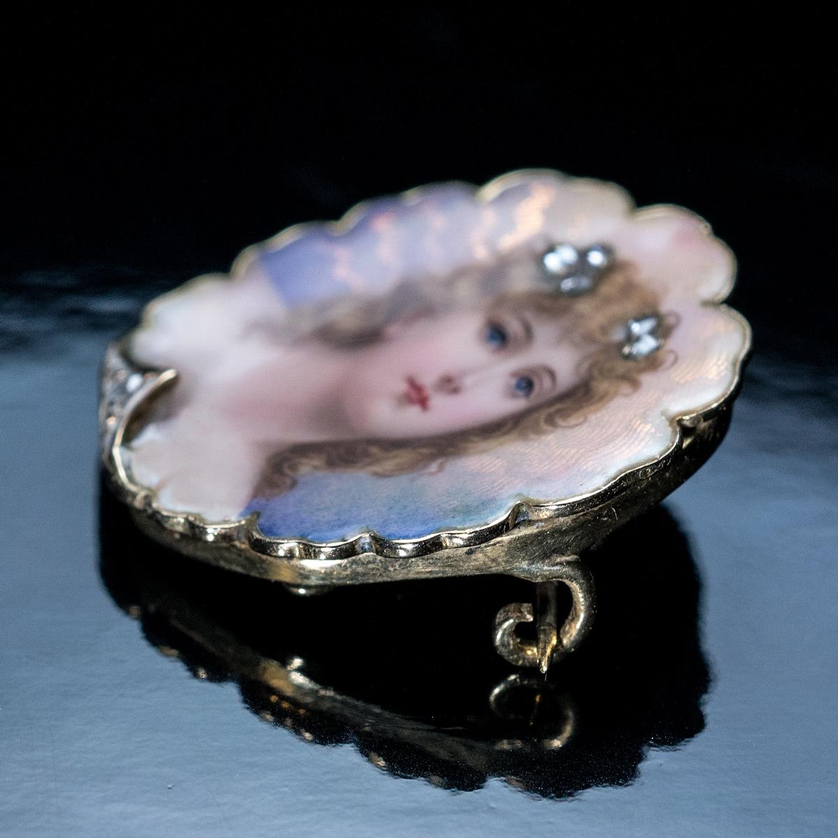 Circa 1900

An antique 18K gold shell-shaped brooch is finely enameled with a beauty of le Belle Epoque on a pinkish-purple guilloche background. The portrait is accented by six tiny rose cut diamonds.

The design is influenced by the Art Nouveau