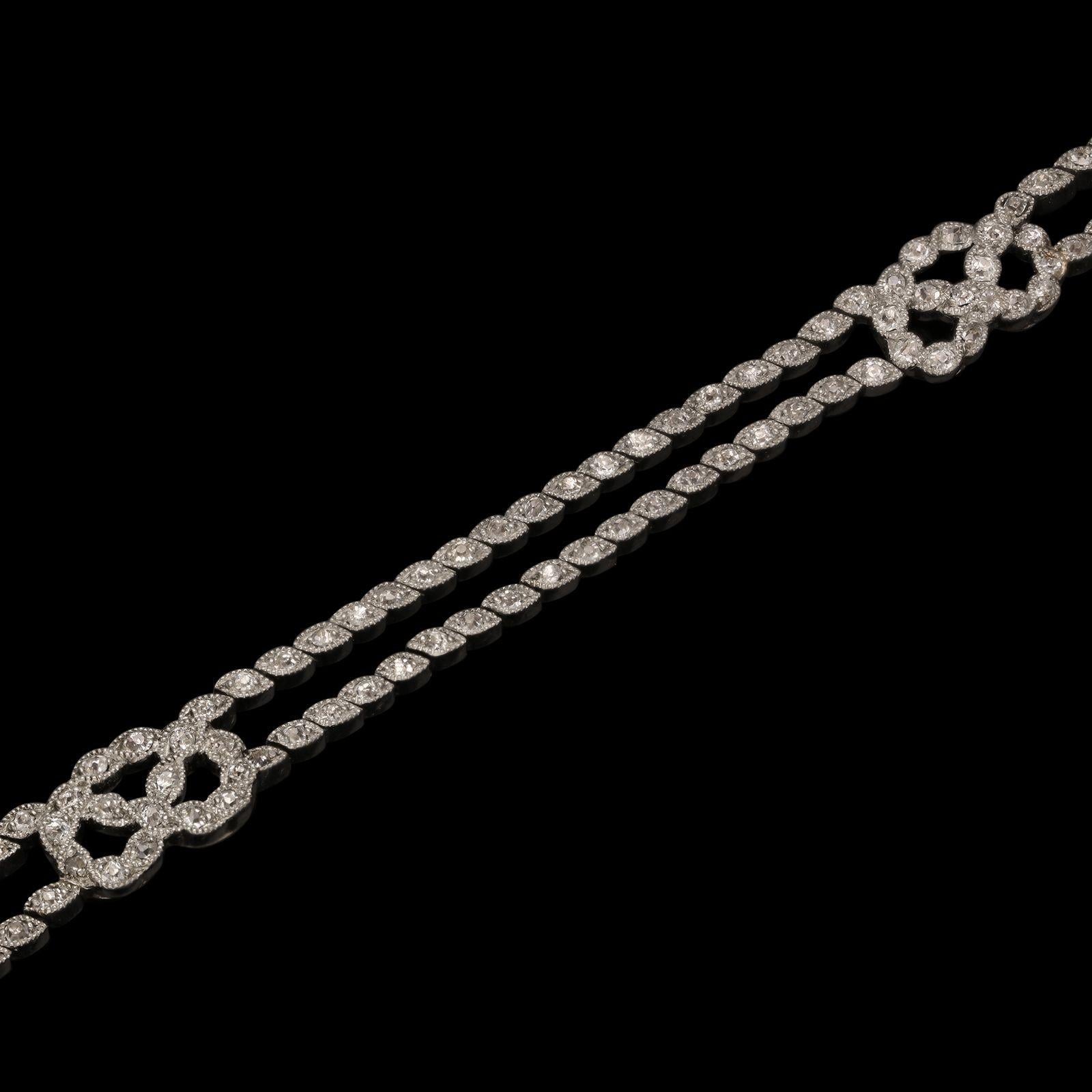 Superbe bracelet Belle Epoque en diamants et platine, datant de 1910 environ, formé de deux rangées de diamants de taille ancienne sertis dans des colliers en platine de forme marquise, avec une bordure en mille-grains placée en diagonale donnant