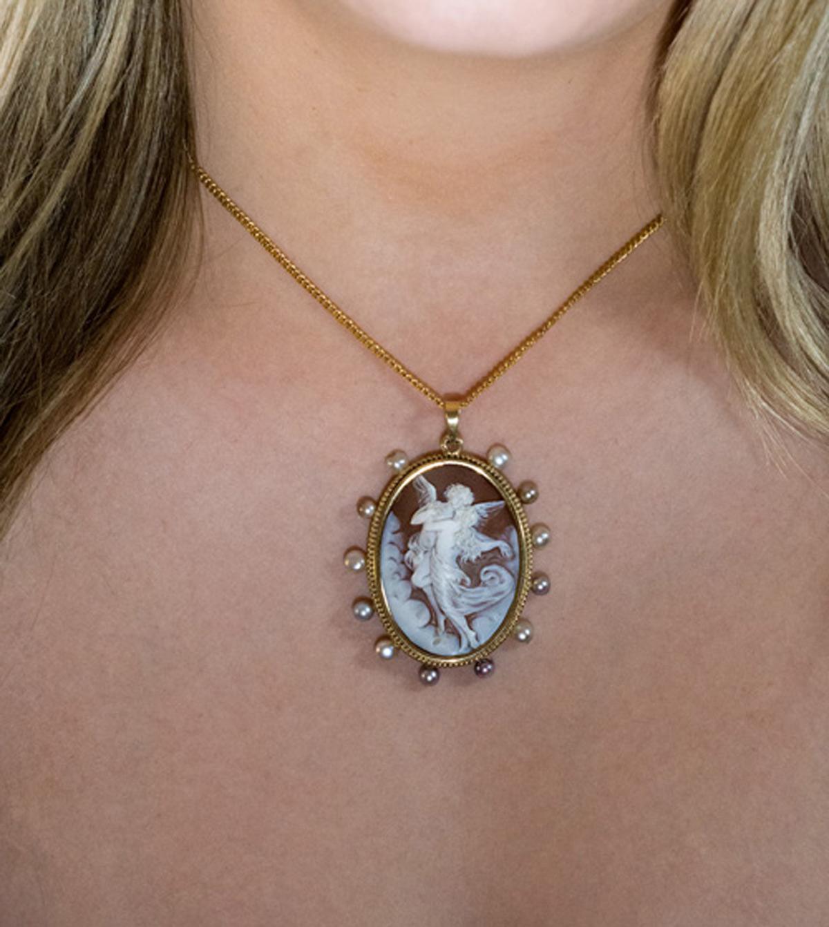 Circa 1890

This Belle Époque antique pendant features a superbly carved shell cameo depicting Cupid and Psyche. The cameo is set in a 14K gold bezel encircled by white, cream and gray pearls.

The pendant measures without bail 49 x 40 mm (1 15/16 x