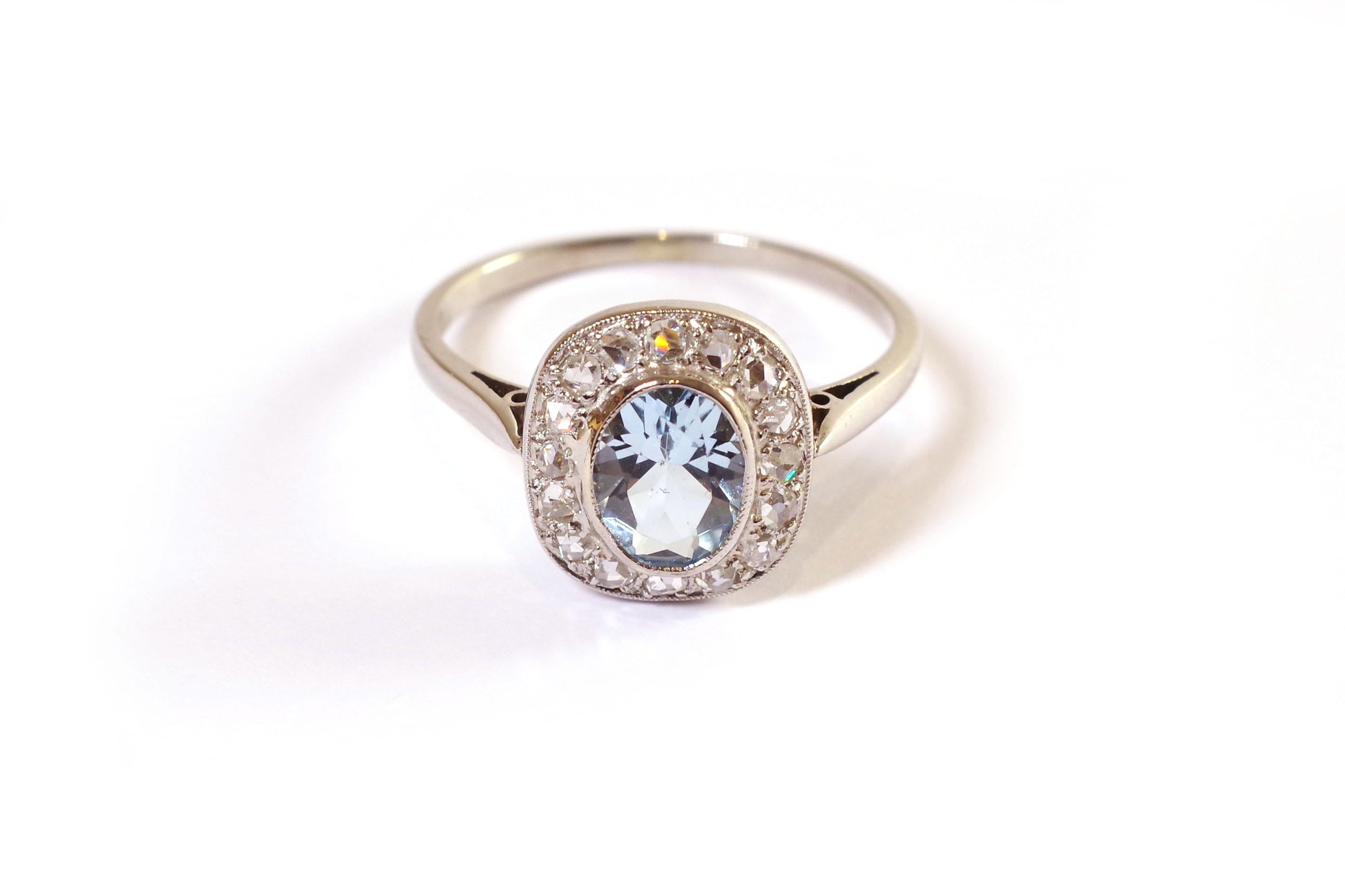 Belle Epoque aquamarine diamonds ring in gold and platinum. Antique ring set with an aquamarine in a surround of sixteen diamonds cut in rose. The setting is closed and pearled. The aquamarine weighs 1.20 carats and has a beautiful ice blue color.