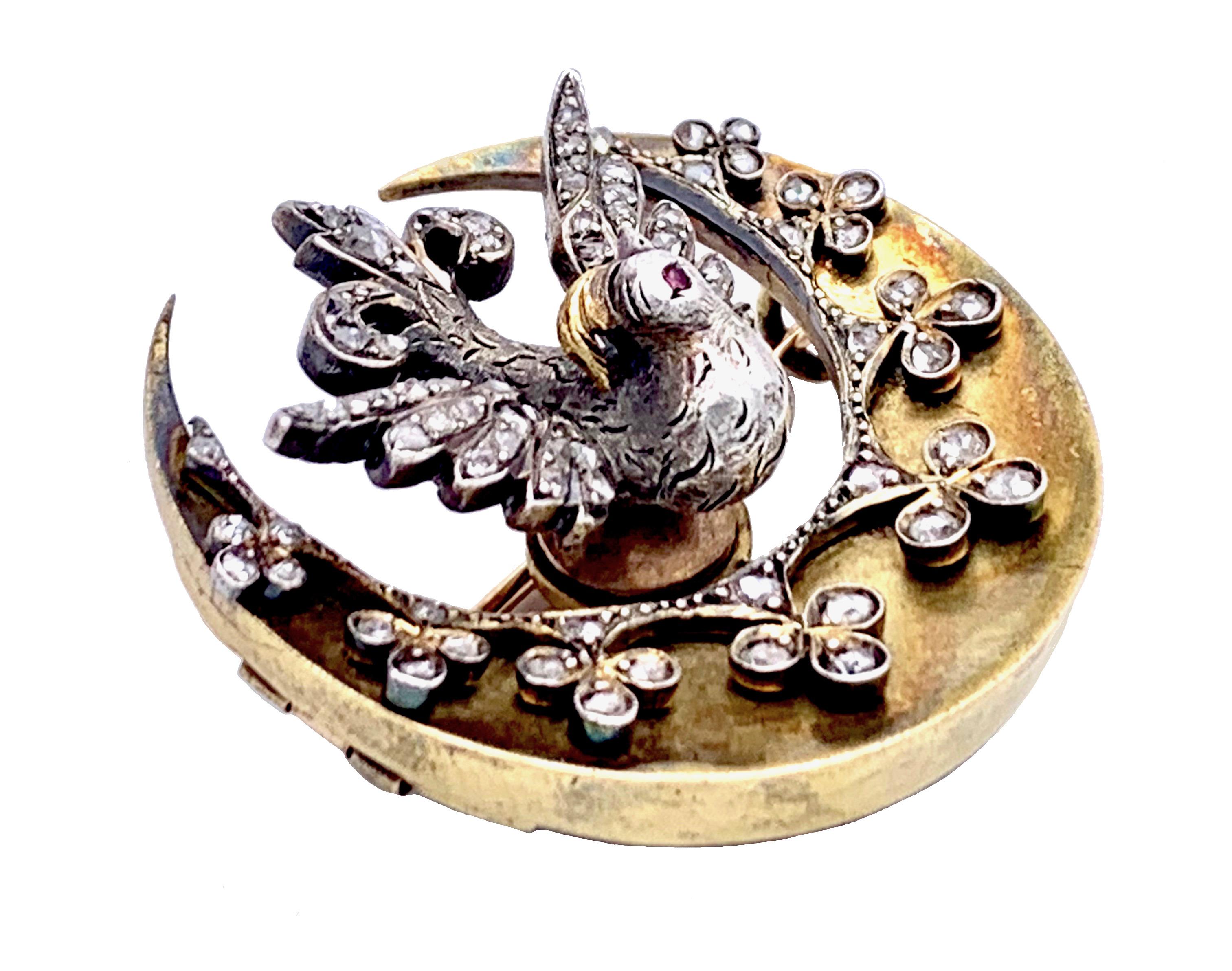 Cette pièce de joaillerie des plus charmantes a été conçue comme un oiseau du paradis debout sur un croissant décoré de trèfles sertis de diamants. 