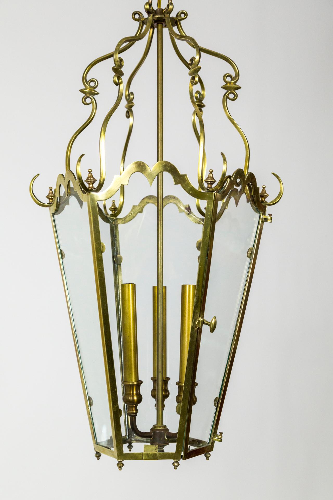 An elegantly decorative six-panel, 3-light glass and brass lantern. French origin - Belle Époque style. Each glass panel topped in an amazingly shaped brass frame with an even more wonderful birdcage type headdress. France, 1920s. Measures: 29