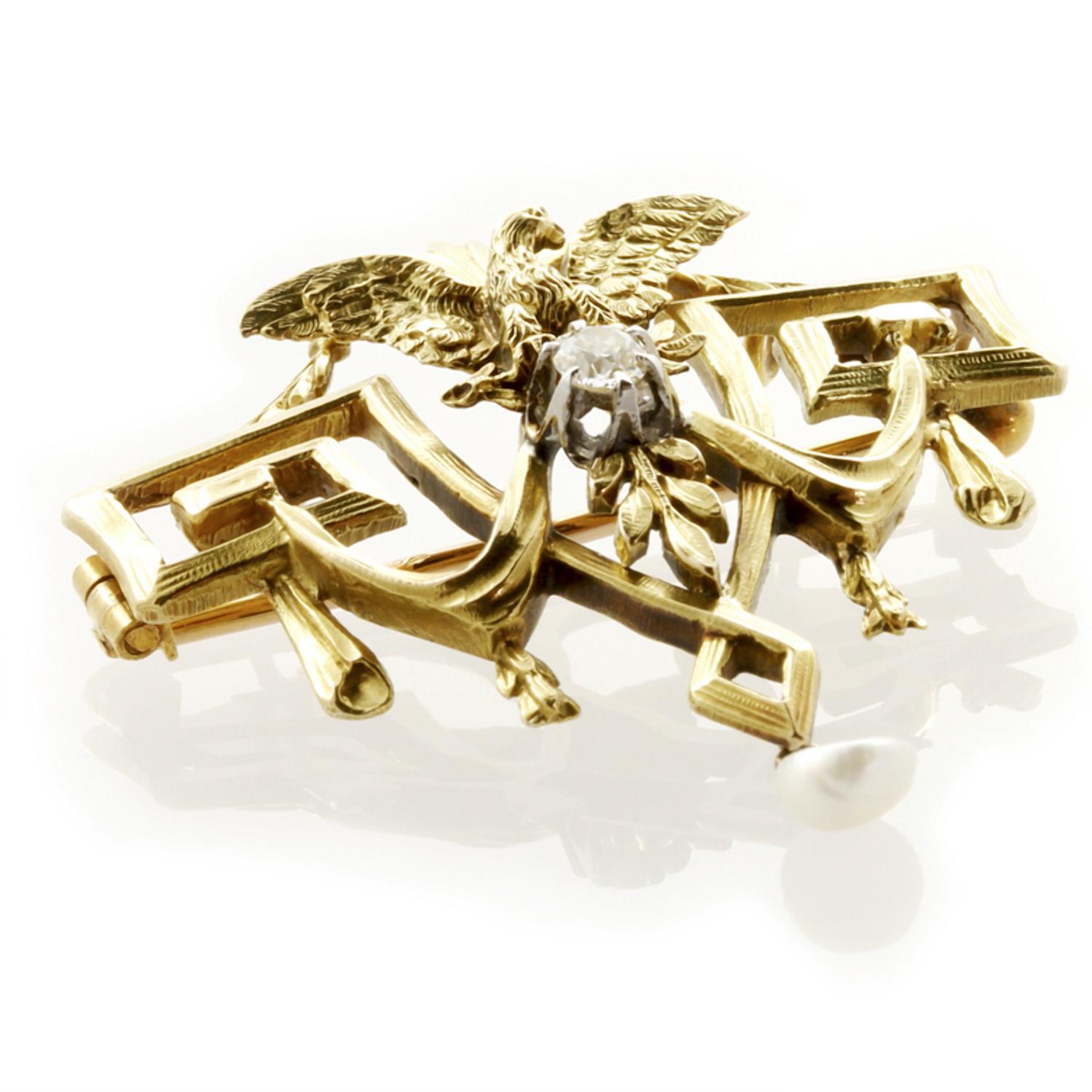 A Belle Époque carved yellow gold eagle brooch, of neo-classical design including swags, Greek-key motifs and a centrally carved eagle surmounting a single claw-set old brilliant-cut diamond estimated to weigh 0.2 carats, all mounted in gold and