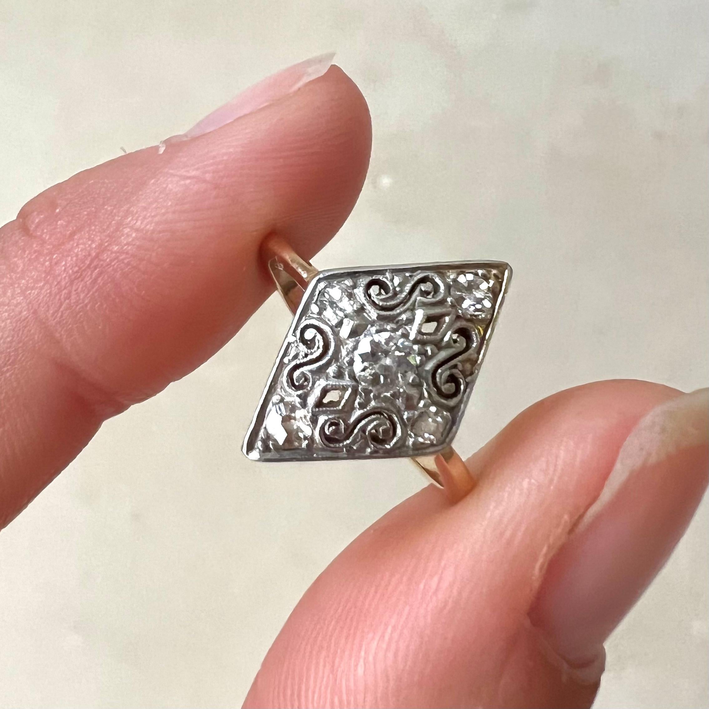 A gorgeous navette ring adorned with intricate swirling work and embellished with five diamonds, this diamond-shaped Belle Epoque ring exudes timeless elegance. 

At its center gleams a captivating diamond weighing approximately 0.18 carats, adding