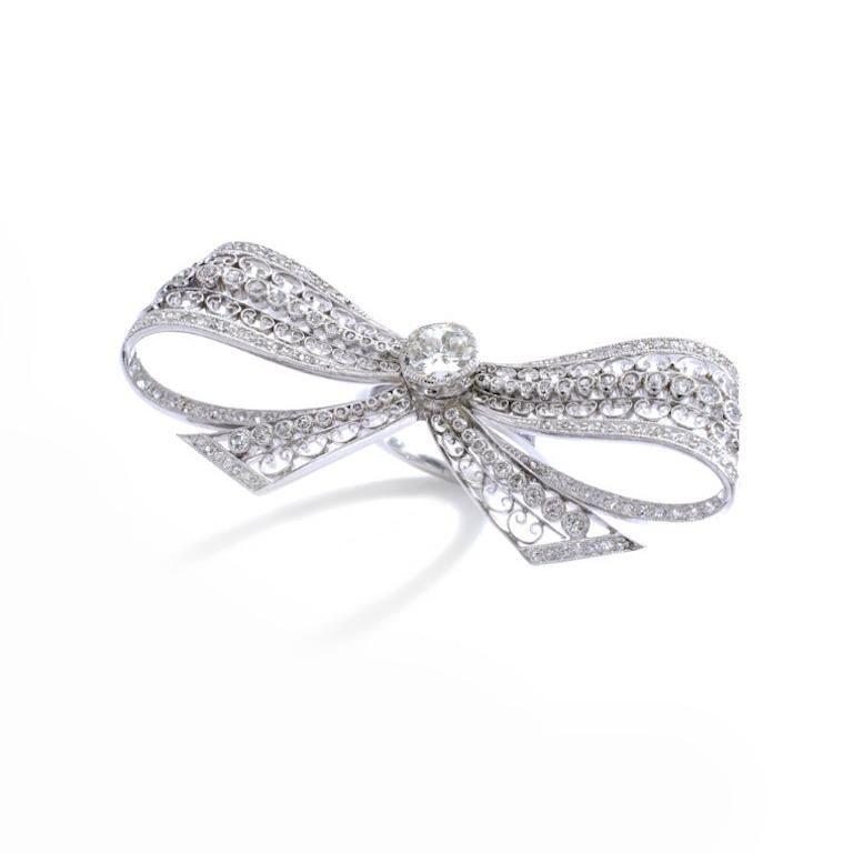 Introducing a truly exquisite piece, the Platinum and old mine diamond bow ring. This stunning ring showcases the timeless elegance of lace, beautifully reimagined in a bow design. Crafted with the finest platinum, this ring is a true statement of