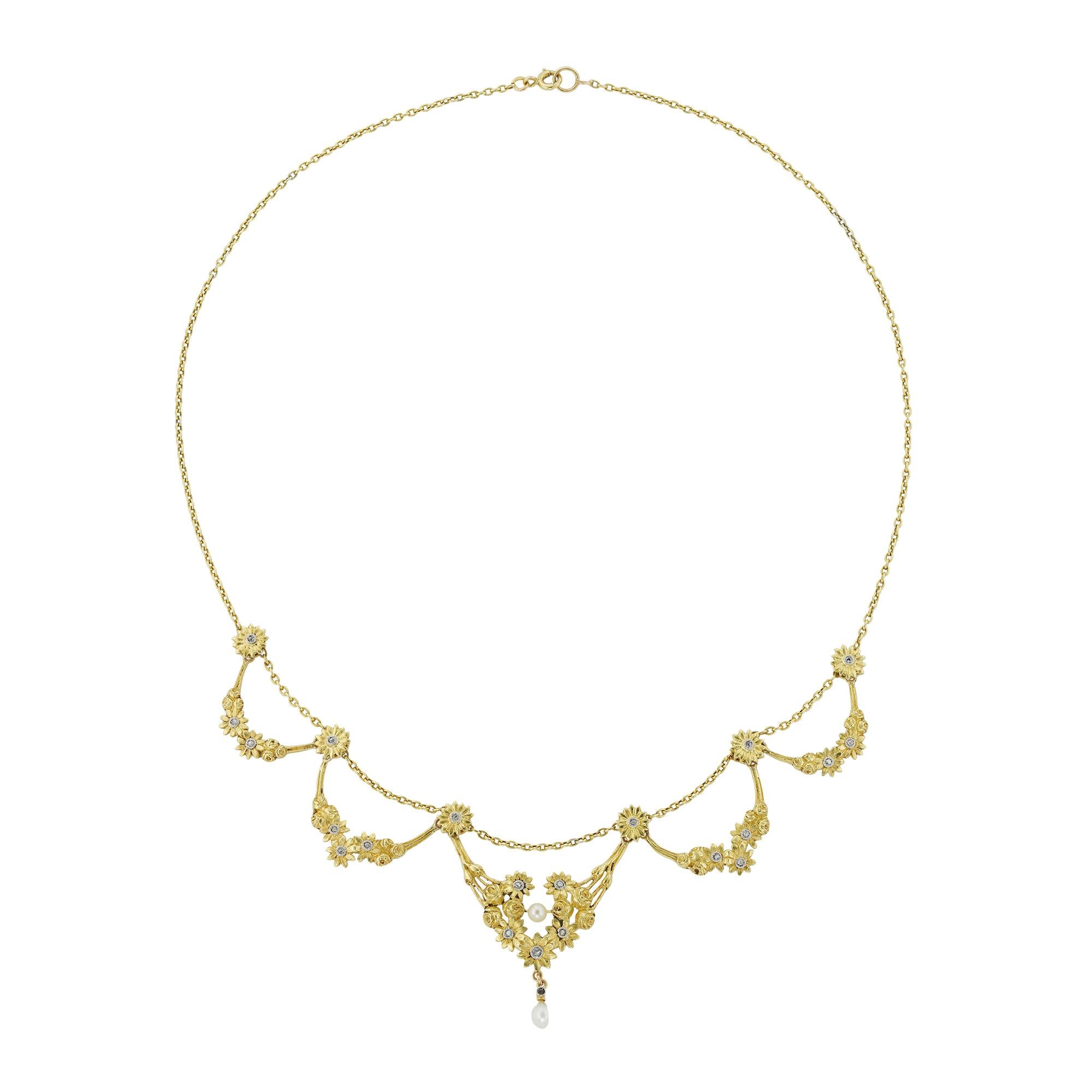A Belle Époque diamond-set floral swag necklace, consisting of graduating flower garlands of roses and daisies, with the centre swag suspending a pearl drop, all attached to a trace chain, bearing French marks for 18ct gold, circa 1890, measuring