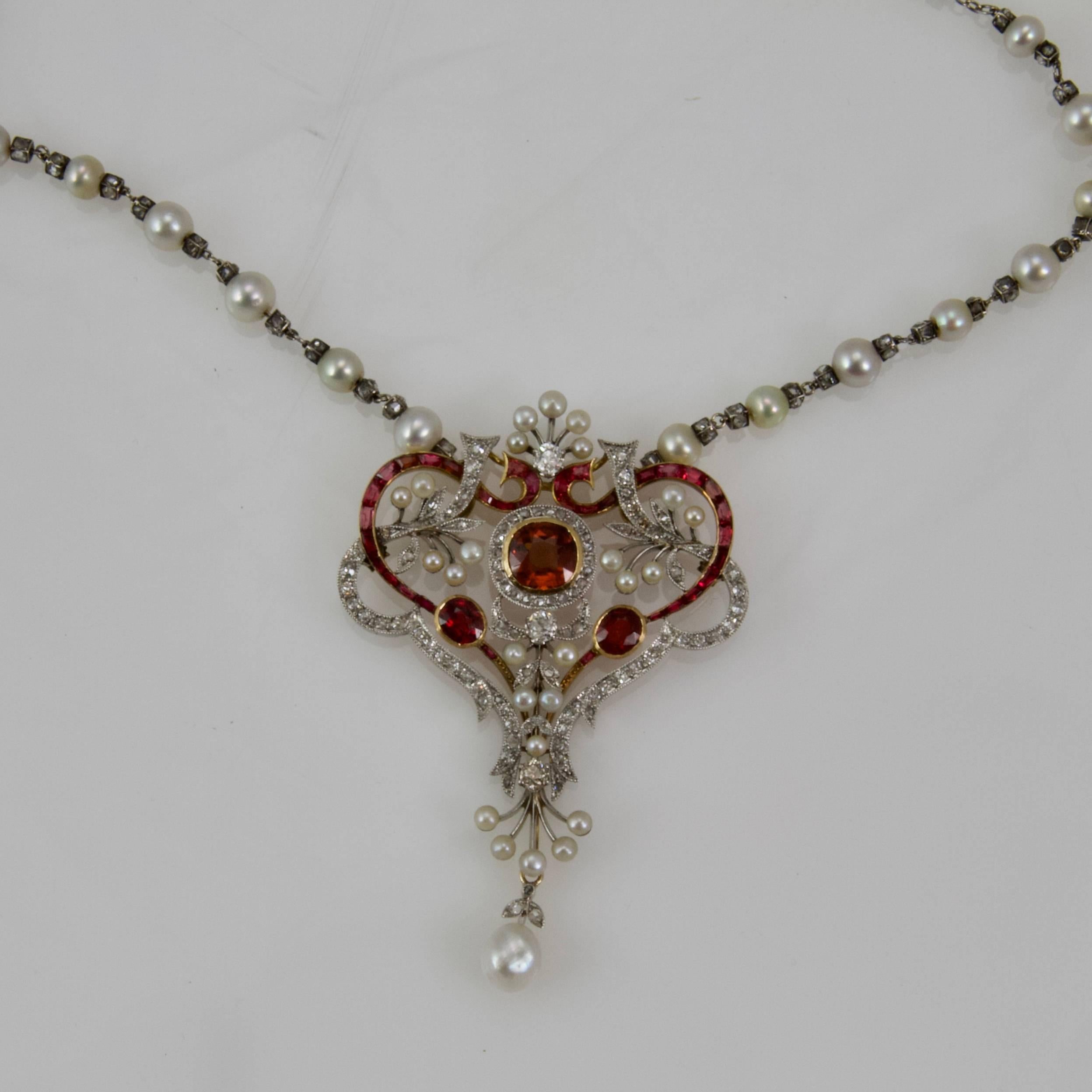 Pendent and its chain typically of Belle Epoque Period. 
Designed with heart and leaves pattern interlaced. 
The main stone is a spinelle red orangy. 
Overall set in 