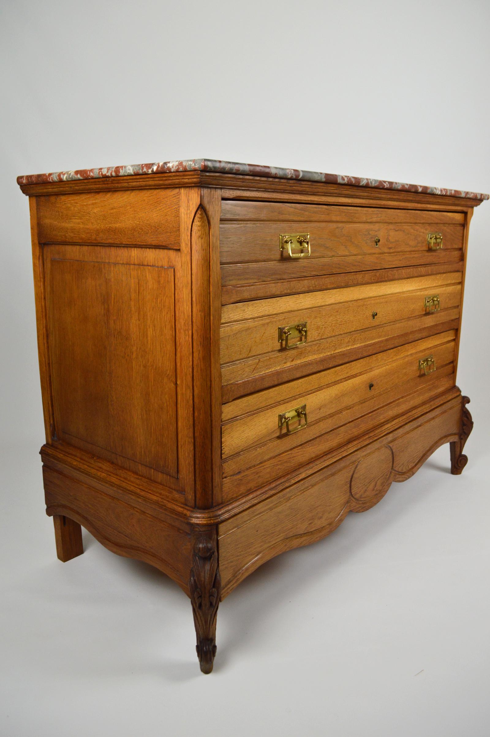 Superb Belle Époque commode or chest of drawers.

In oak, top in red marble, brass handles.

4 drawers, including 1 