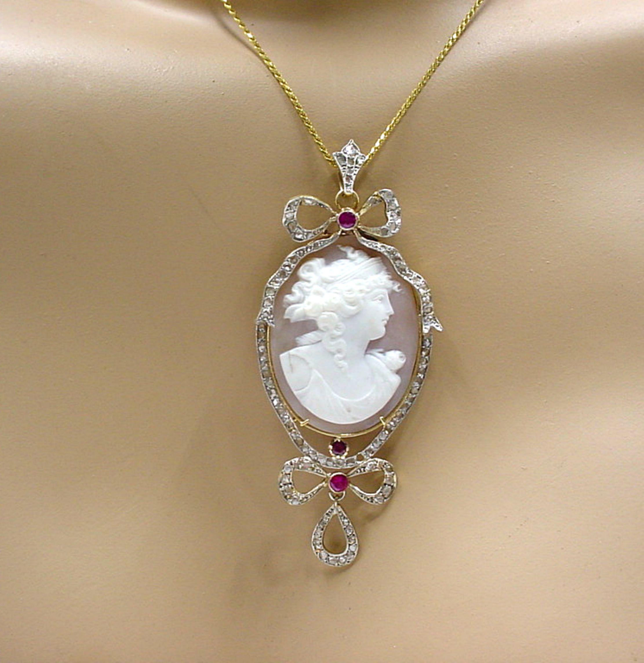 Elegant and wearable  Edwardian card shell cameo with a dazzling frame of old cut diamond and ruby gemstones...

The dramatic and large pendants' frame rendered in sumptuous platinum topped 18k gold~

METAL: 18k Gold/Platinum. 
GEMSTONES: Rose cut