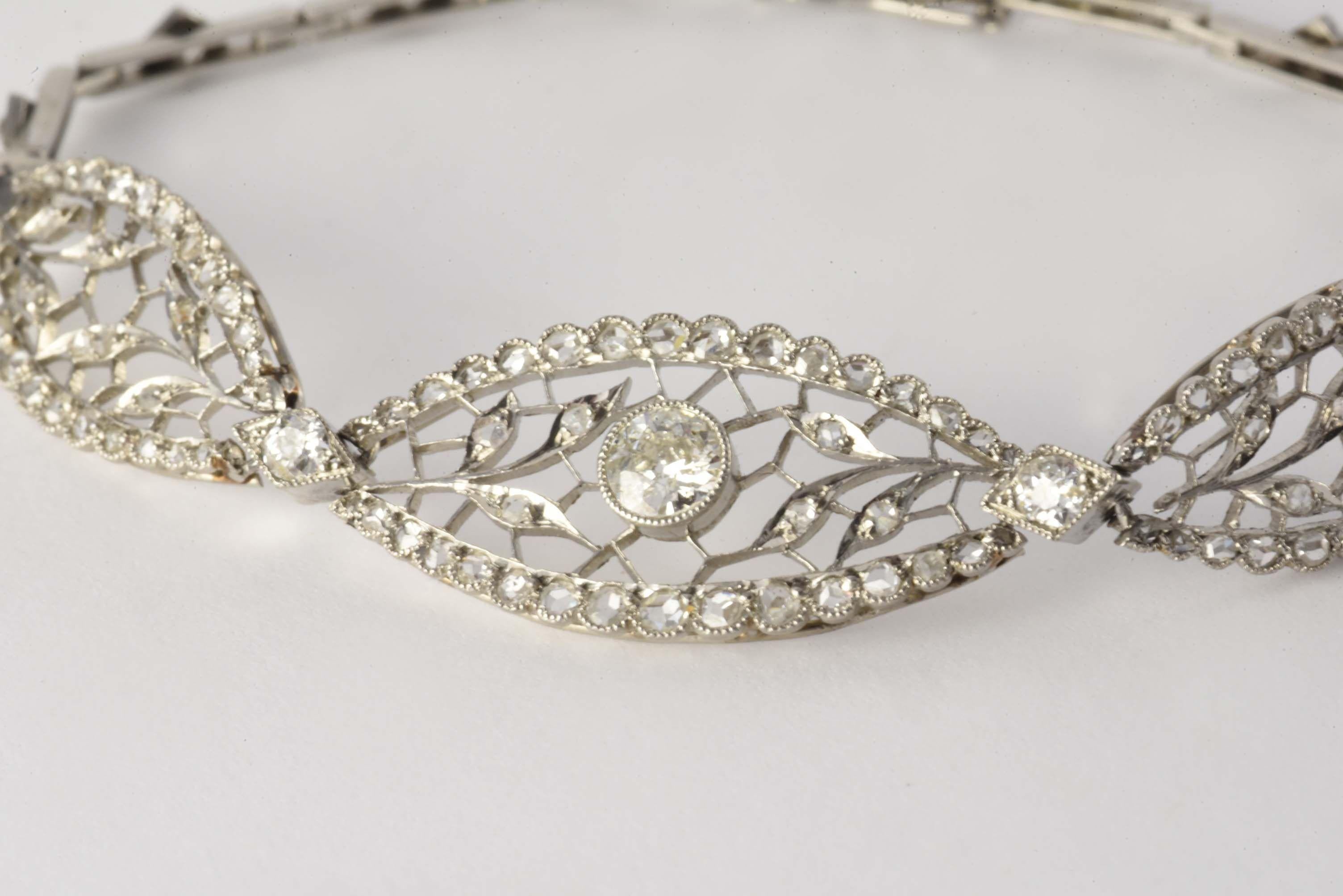 Crafted in 1915 from platinum, this exquisitely designed Belle Epoque bracelet features an Old European cut diamond center stone measuring 0.30 carats, G-H color, SI2 clarity, and adorned with rose cut diamonds and fine filigree. Diamonds total 1.35