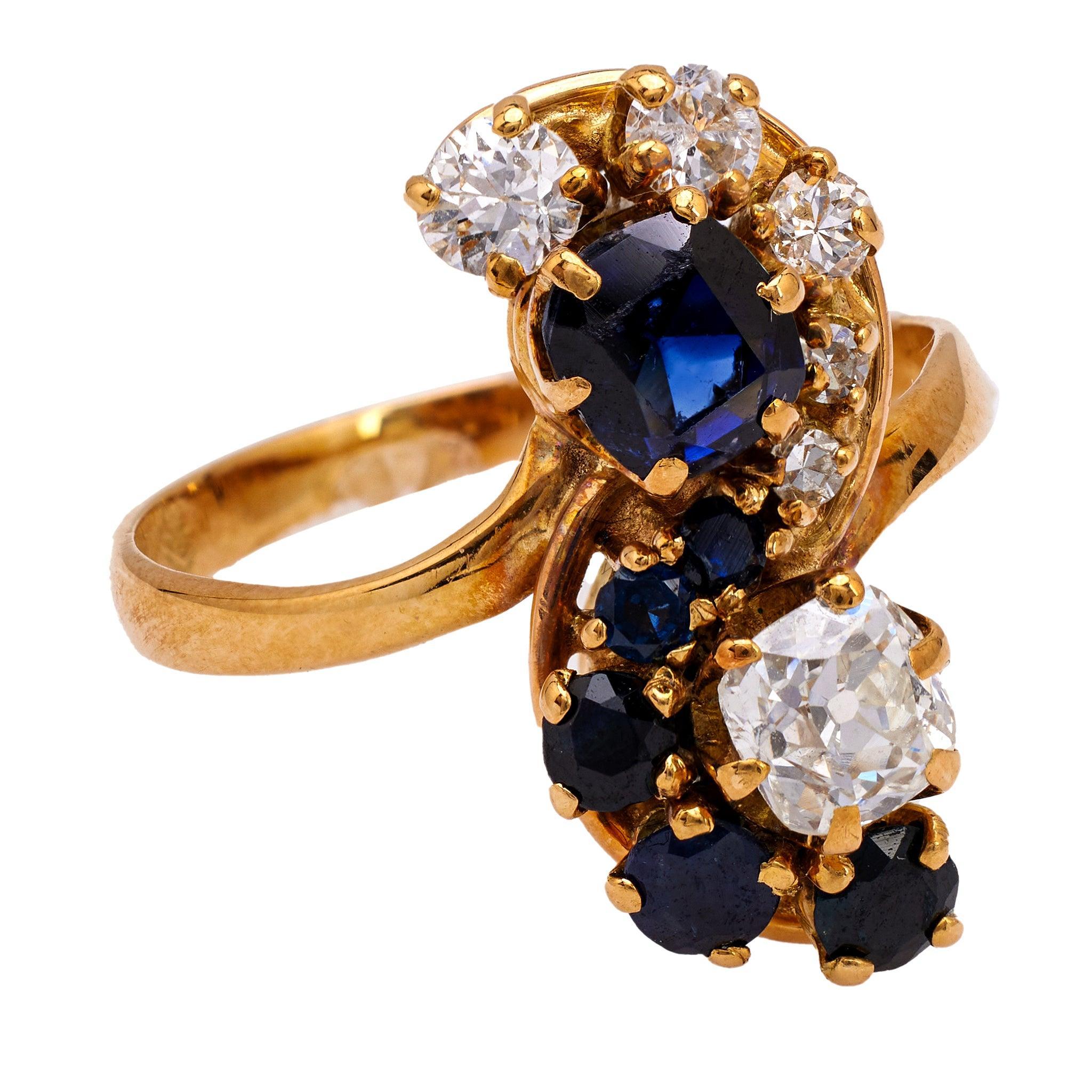 One Belle Époque French Diamond and Sapphire 18k Yellow Gold Toi et Moi Ring. Featuring one old mine cut diamond weighing approximately 0.60 carat, graded K color, SI1 clarity, and one cushion mixed cut sapphire weighing approximately 0.80 carat.