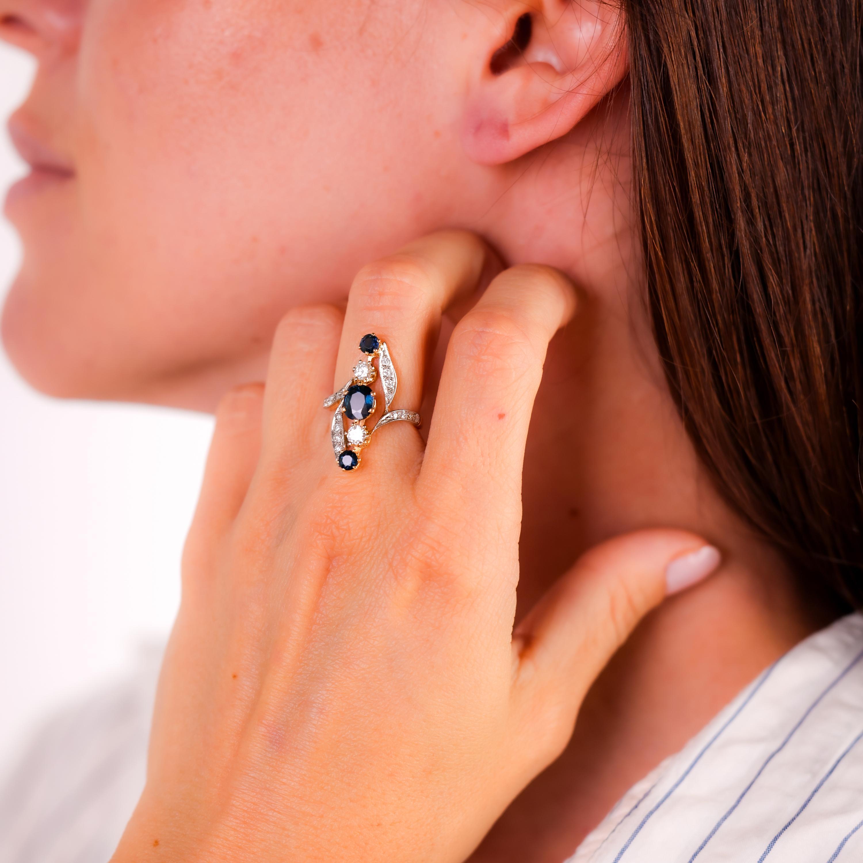 Center Stone: 1 Oval Cut and 2 Round Brilliant Cut Blue Sapphires
Weight: Approximately 1.6 Carats
Accent Stone: 18 Round Brilliant Cut Diamonds
Total Diamond Weight: Approximately .70 Carats
Color: G
Clarity: VS-SI
Metal: 18K Rose and White