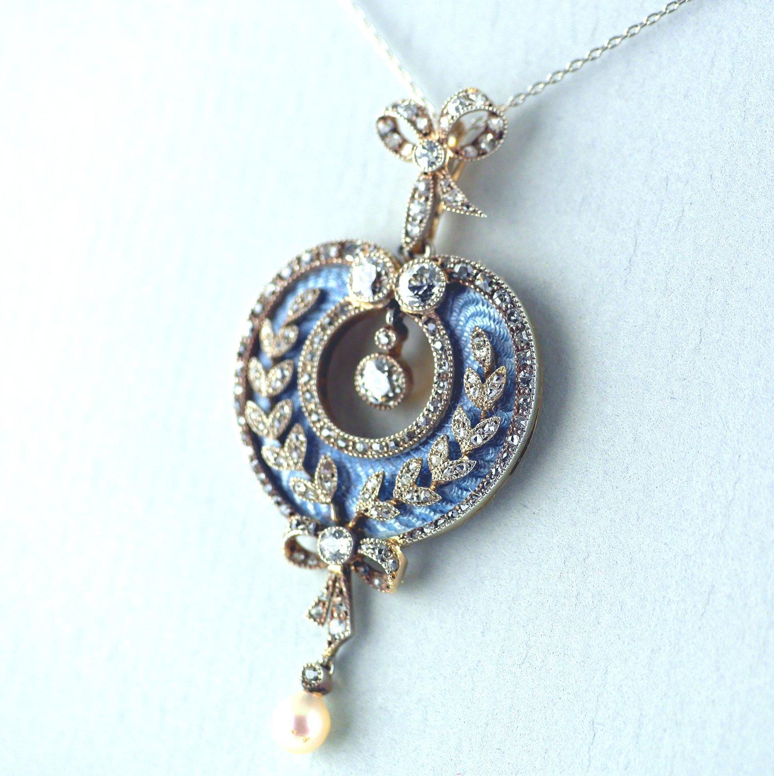 An exquisite, rare and fine Belle Epoque pendant in 18 carat gold and platinum, circa 1900 with a detachable brooch fitting. 

18 carat gold and platinum set heart shaped centre with a diamond foliate overlay on engine turned, pale blue, translucent