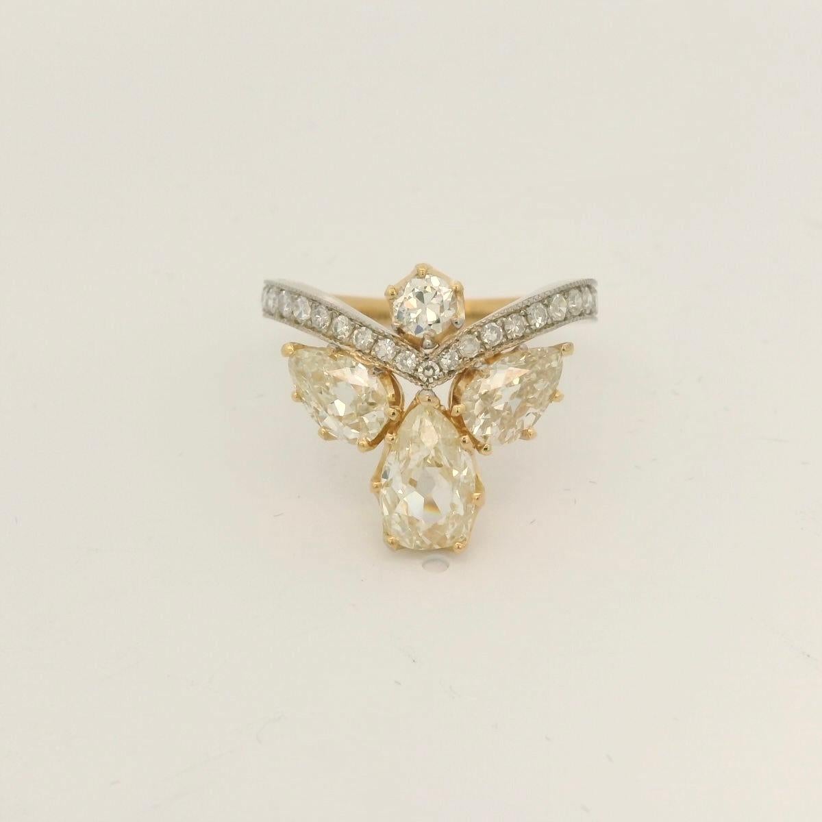 Bicolore yellow and white gold 18 Karat ring inspired by the Belle époque. 

Very charming ring with unique old cut diamonds with very rare champagne color old cut diamonds. 

Suits perfectly on the Hand. 

The ring is set with an old cut pear shape