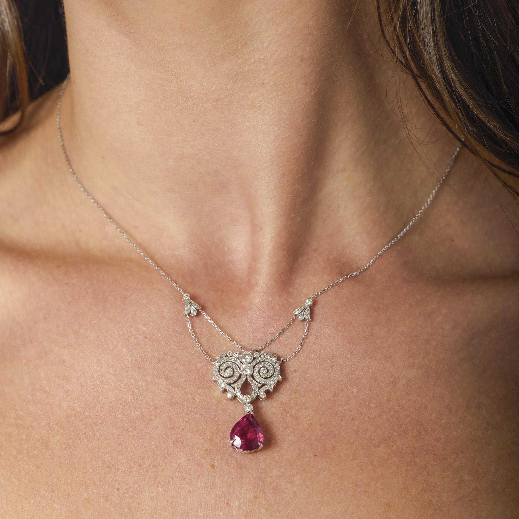 This elegant Belle Époque inspired necklace showcases a vivid pear shape rubellite surrounded by a halo of brilliant diamonds, gracefully set in polished 18k white gold.