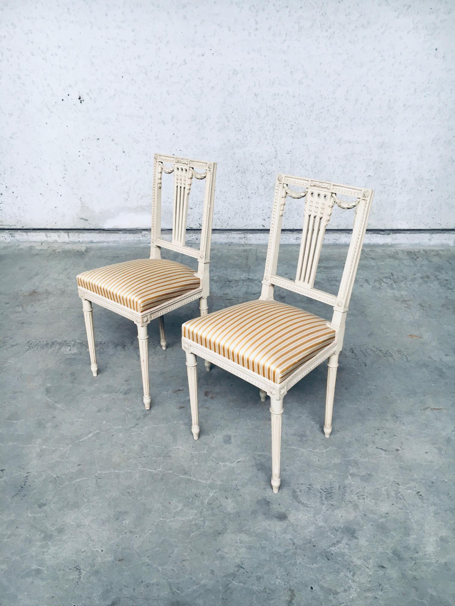 Vintage Antique Belle Epoque French Louis XVI Style design dining chair set of 2, made in France 1940's. Original cream paint patinated leaf and flower carved frame with silk fabric seats. Both are in very good, original condition. Wear and patina