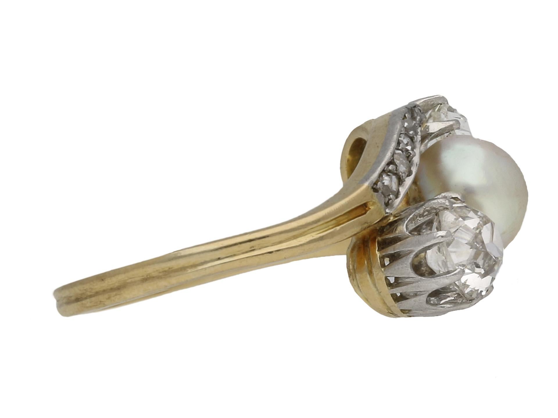 Belle Époque pearl and diamond three stone cross over ring. Set to the centre with a round natural saltwater pearl in a closed back setting, approximately 6.5 x 4.8mm, further set with two cushion shape old mine diamonds in open back claw settings