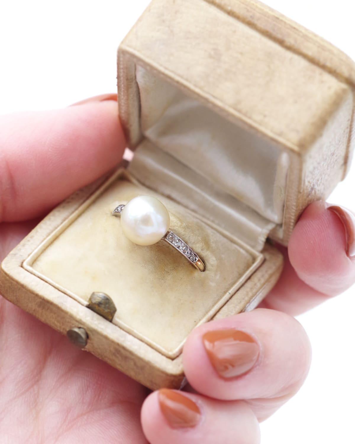 Anello solitario con perla fine certificata in oro 18 carati e platino. Un anello Belle Époque con incastonata una perla a bottone color crema. Sulle spalle dell'anello sono incastonati dieci diamanti a taglio singolo. Anello Belle Époque, circa