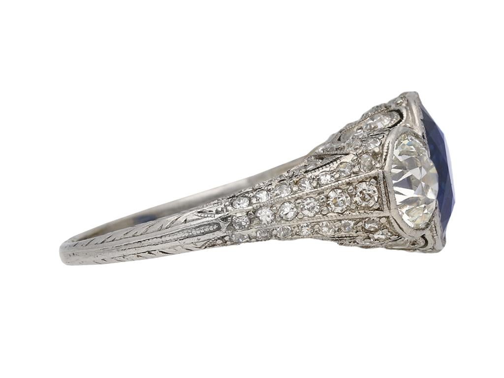 Edwardian sapphire and diamond ring. Set with a cushion shape old cut natural unenhanced sapphire to centre in an open back rubover millegrain setting with an approximate weight of 3.50 carats, flanked by two round old cut diamonds in open back