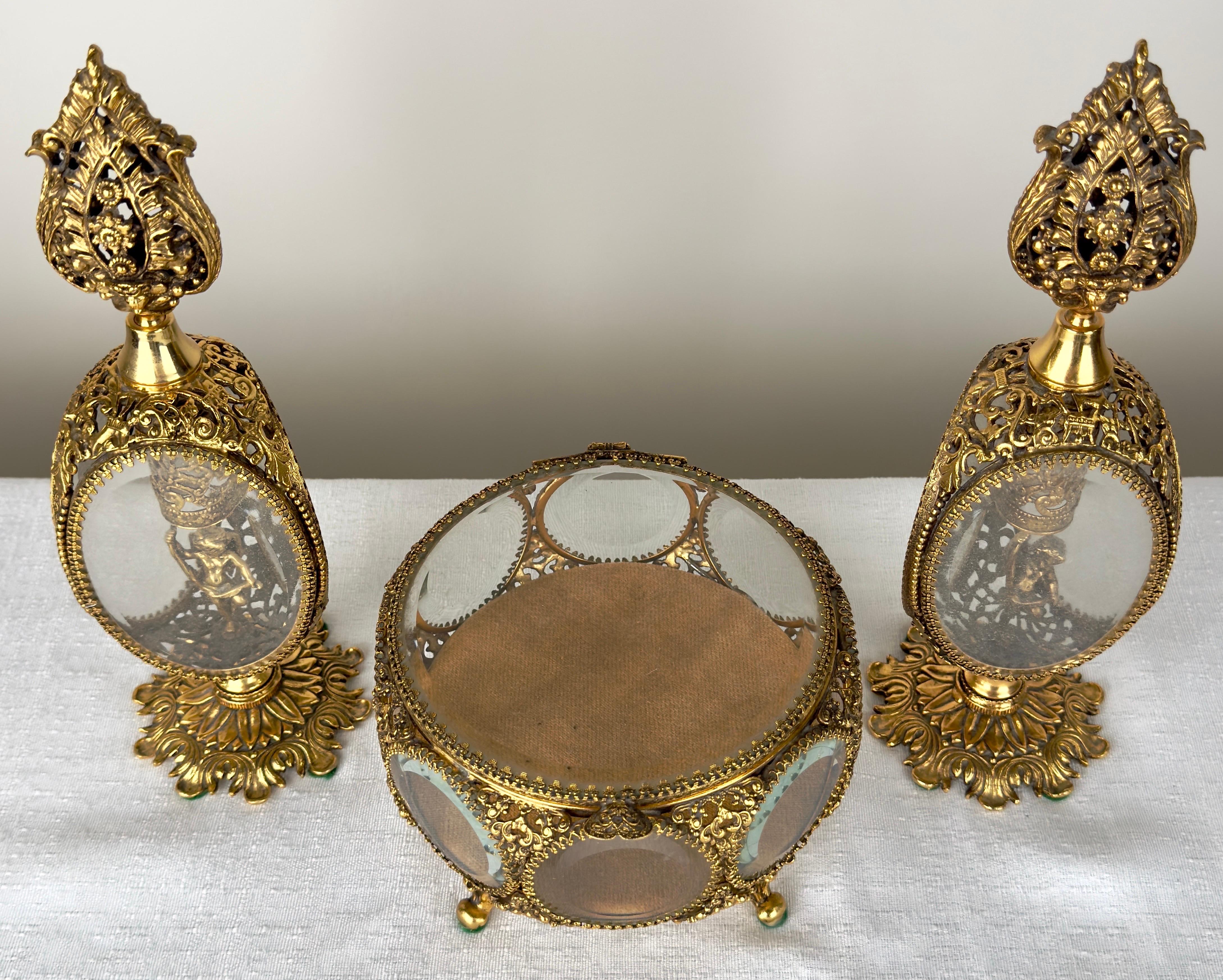 Un ensemble de flacons de parfum et de boîtes à bijoux en filigrane doré de la Belle Époque, illustrant l'opulence de l'artisanat associé à la fin du XIXe siècle et au début du XXe siècle. La paire de flacons de parfum est encadrée d'un Design/One