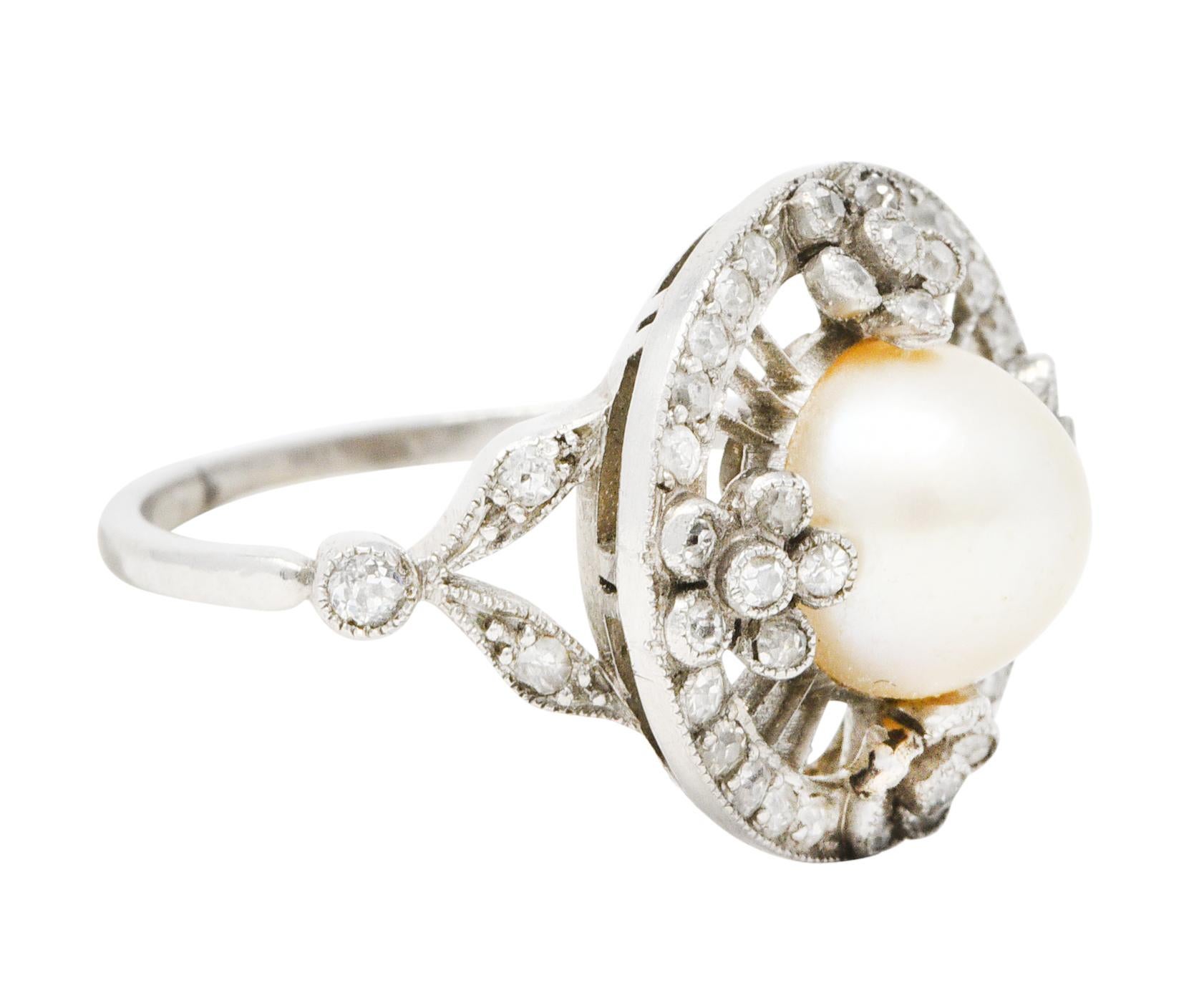 Circular cluster ring centers an 8.0 mm pearl - strong cream body color with strong iridescence

Surrounded by a striated design with four floral stations at each cardinal point

With a diamond halo and flanked by split shoulders in a stylized