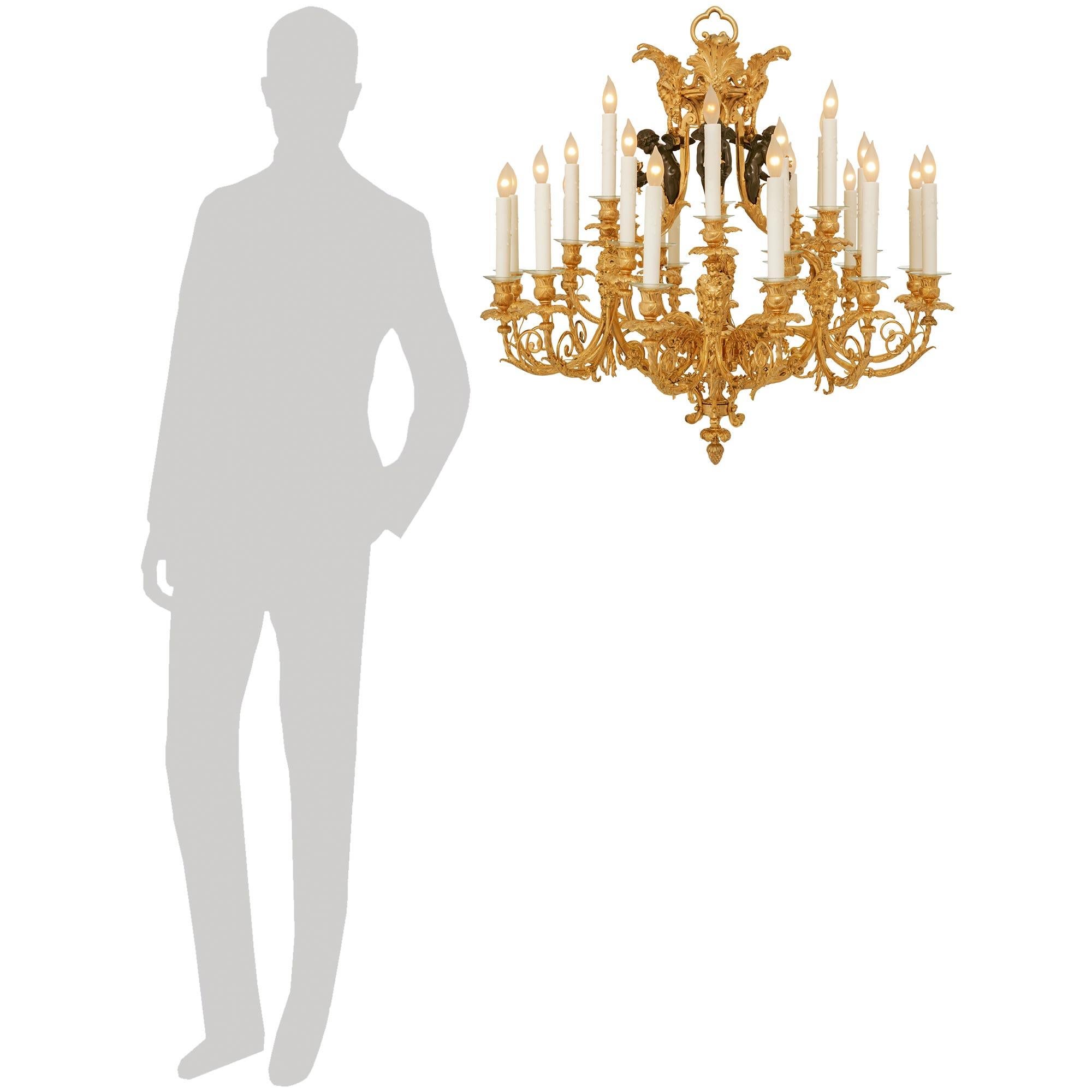 Un lampadario sensazionale e di alta qualità in stile French Belle Epoque del XIX secolo, in stile Luigi XV e bronzo patinato. Questo splendido lampadario a diciotto luci è centrato in basso da un incantevole terminale a fogliame invertito sotto i