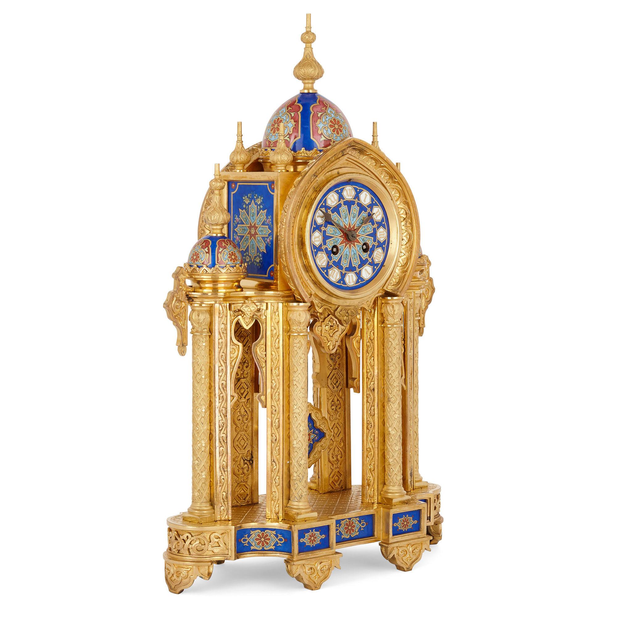 This beautiful clock, formed from gilt bronze and porcelain, is designed and decorated in a discernibly Moorish style. The clock is supported by a flat shaped gilt bronze base, the base supporting four gilt bronze columns that support the gilt