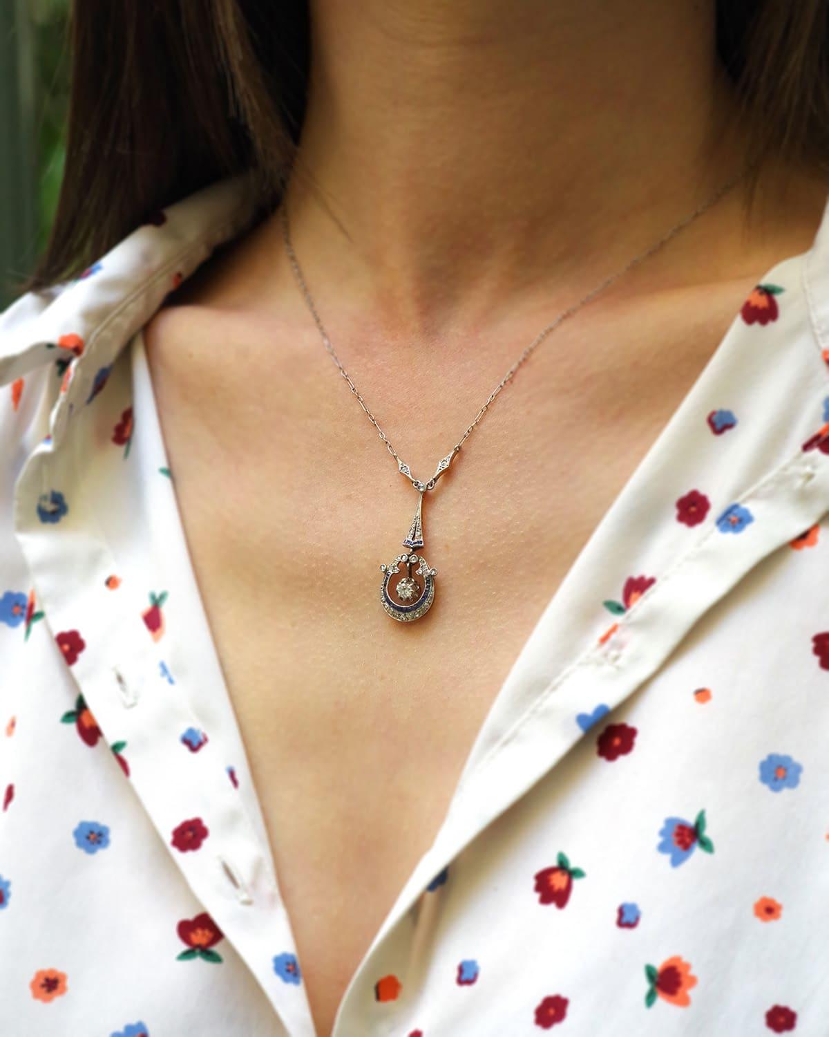 Collana di zaffiri Belle Epoque in platino e oro 18 carati. Collana realizzata con una raffinata catena di platino e ornata da un pendente con diamanti e zaffiri naturali calibrati. Il diamante centrale è mobile, ha un taglio antico e pesa circa