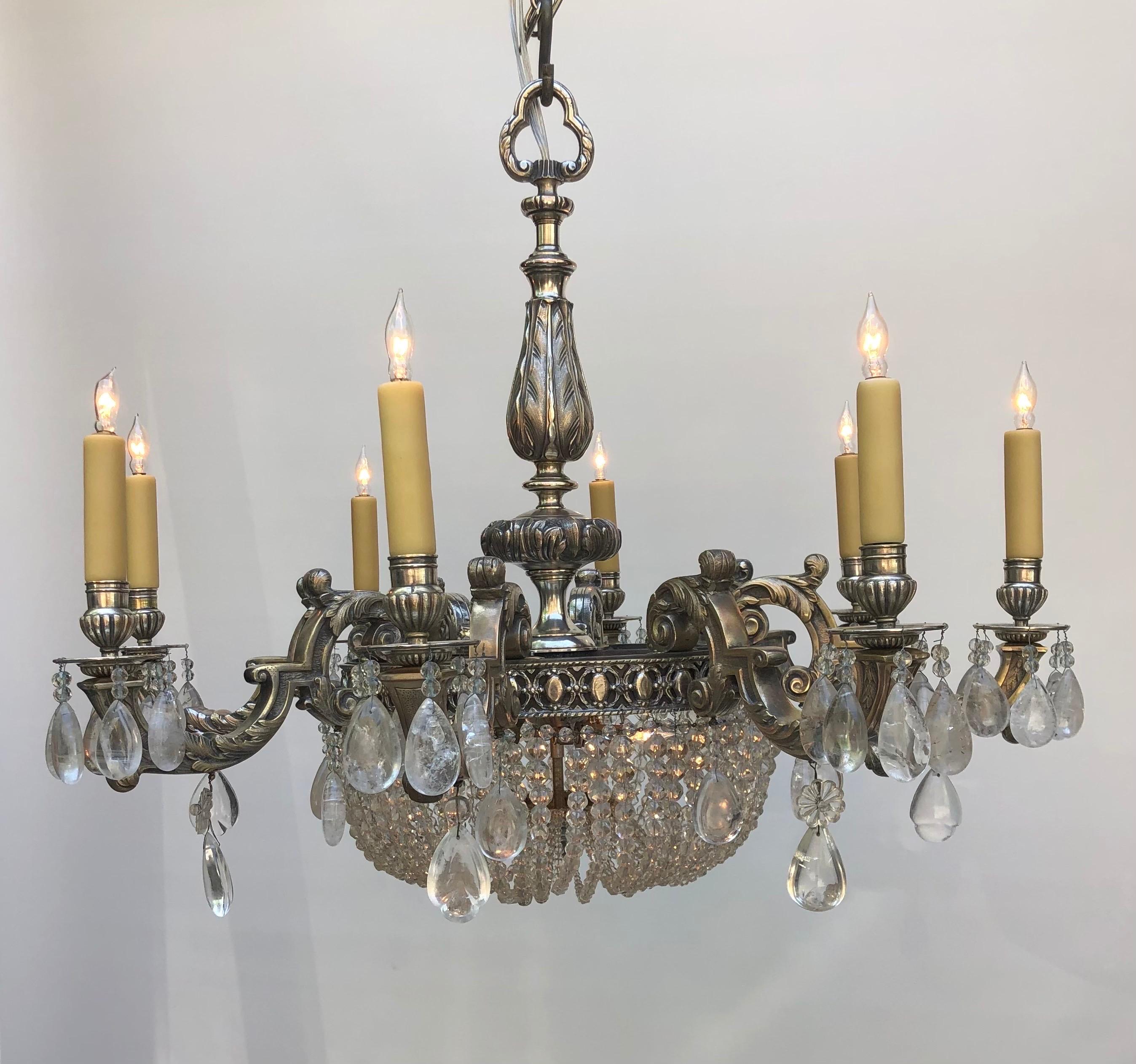 This sophisticated Belle Époque Rock Crystal Silver-plated Bronze Chandelier was made in the early 20th century. This rock crystal silvered chandelier has a refined cast frame with foliage designs on the eight candelabra arms. The silver-plated