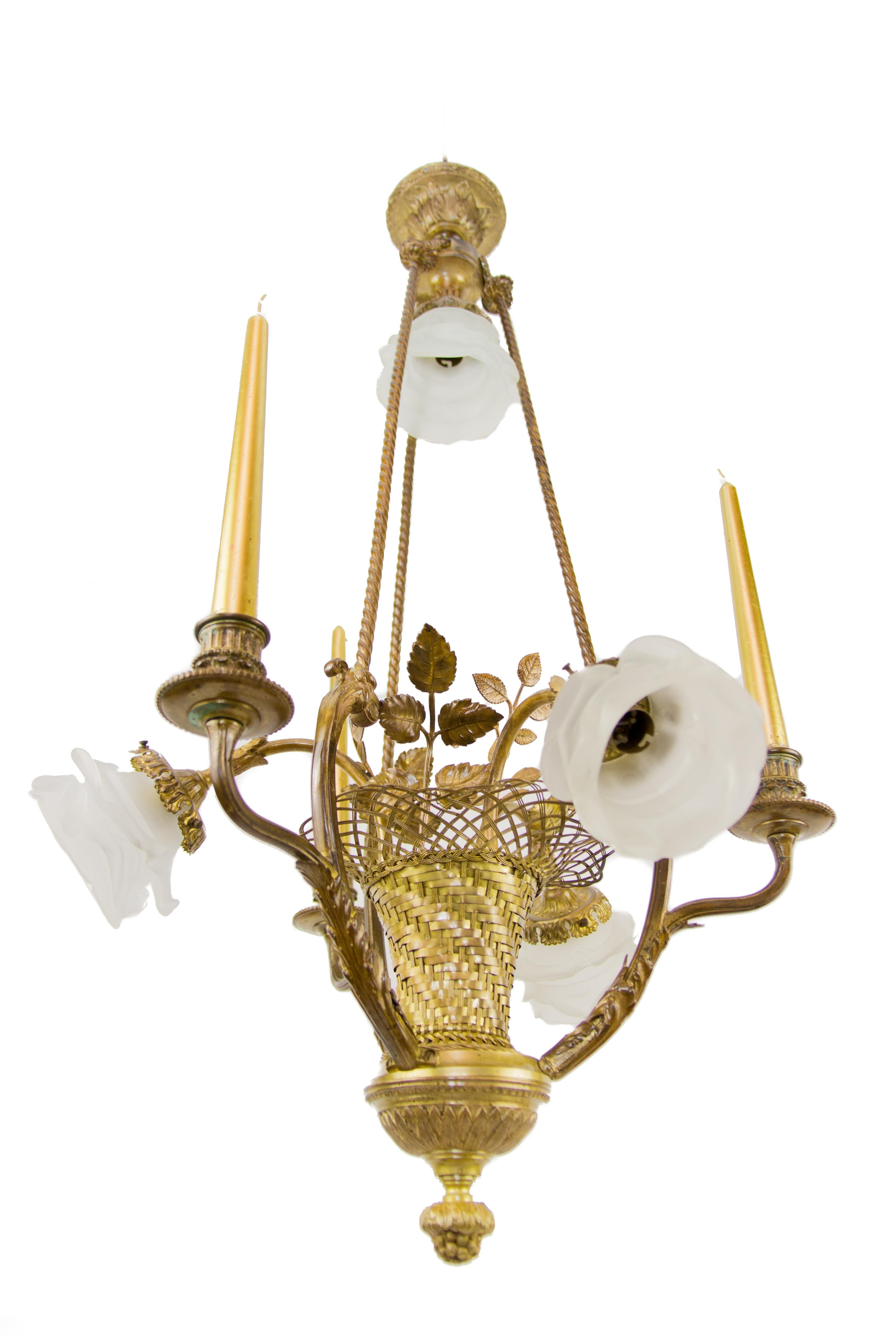 French Belle Epoque bronze woven basket chandelier. Three arms are candle holders, three arms and one light on top have B22 sockets with new wiring, frosted glass flower shaped shades.
Measures: Total height is 33.4 inches / 85 cm; diameter 19.7