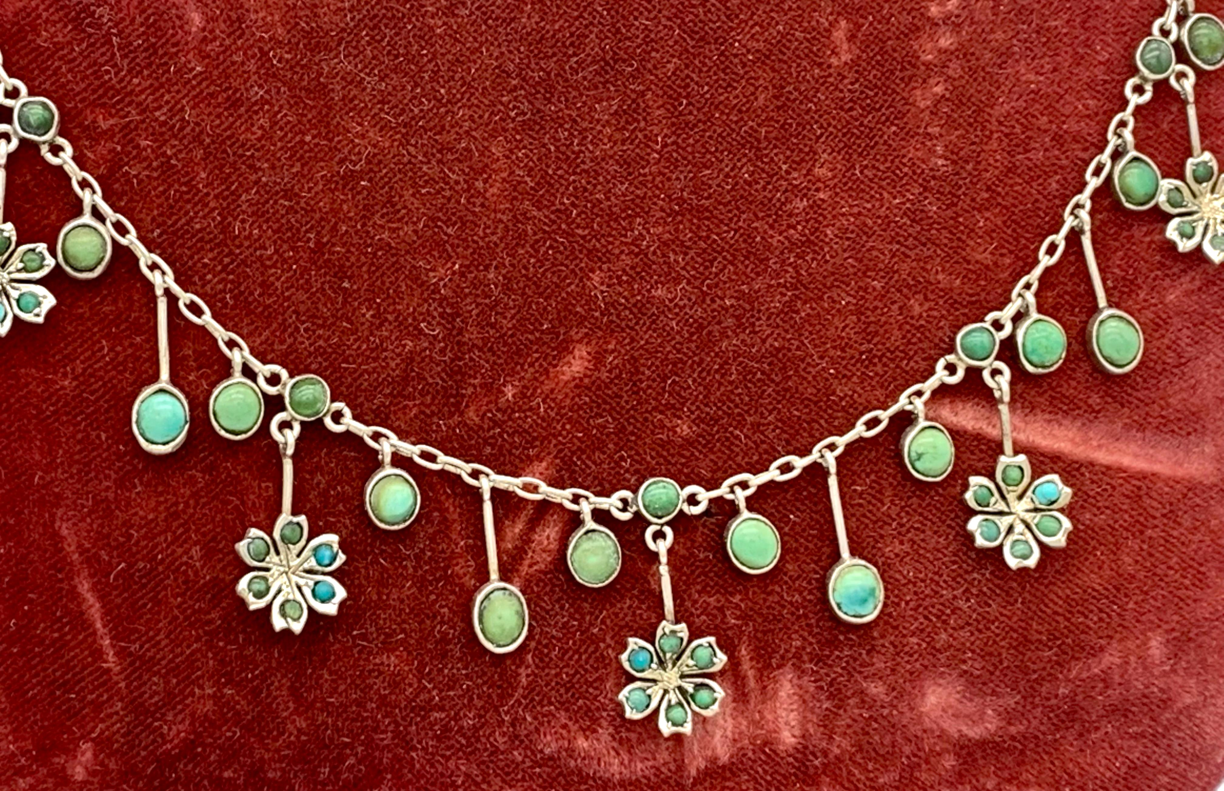 This delicate necklace is has been handcrafted out of silver in the 1890's and features a variety of articulated turquoise set  silver pendants .