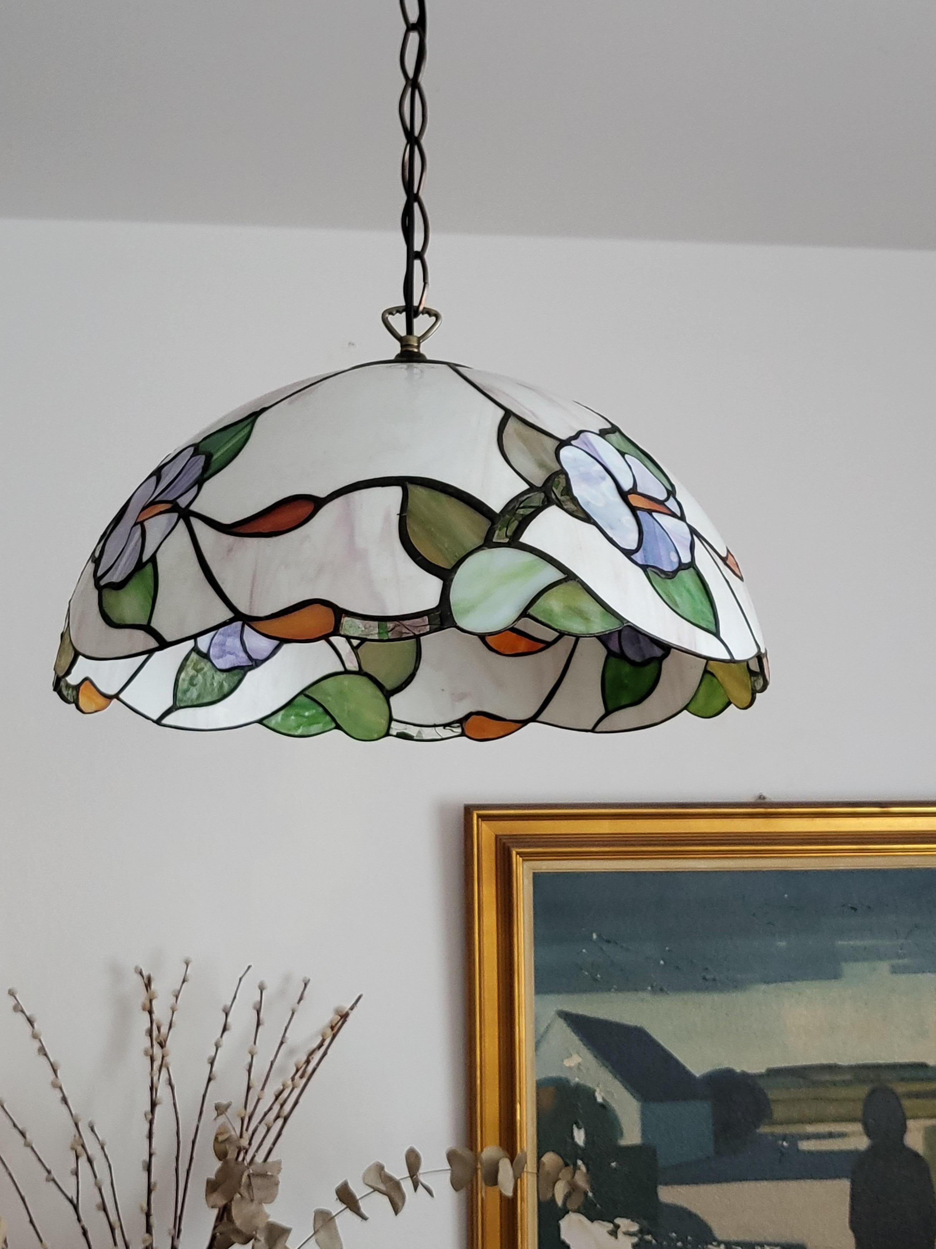 Handmade hanging lamp made of Tiffany glass with holder, chain and ceiling canopy made of patinated brass. E
E 27 bulb is needed.

Very nice condition, no damages.