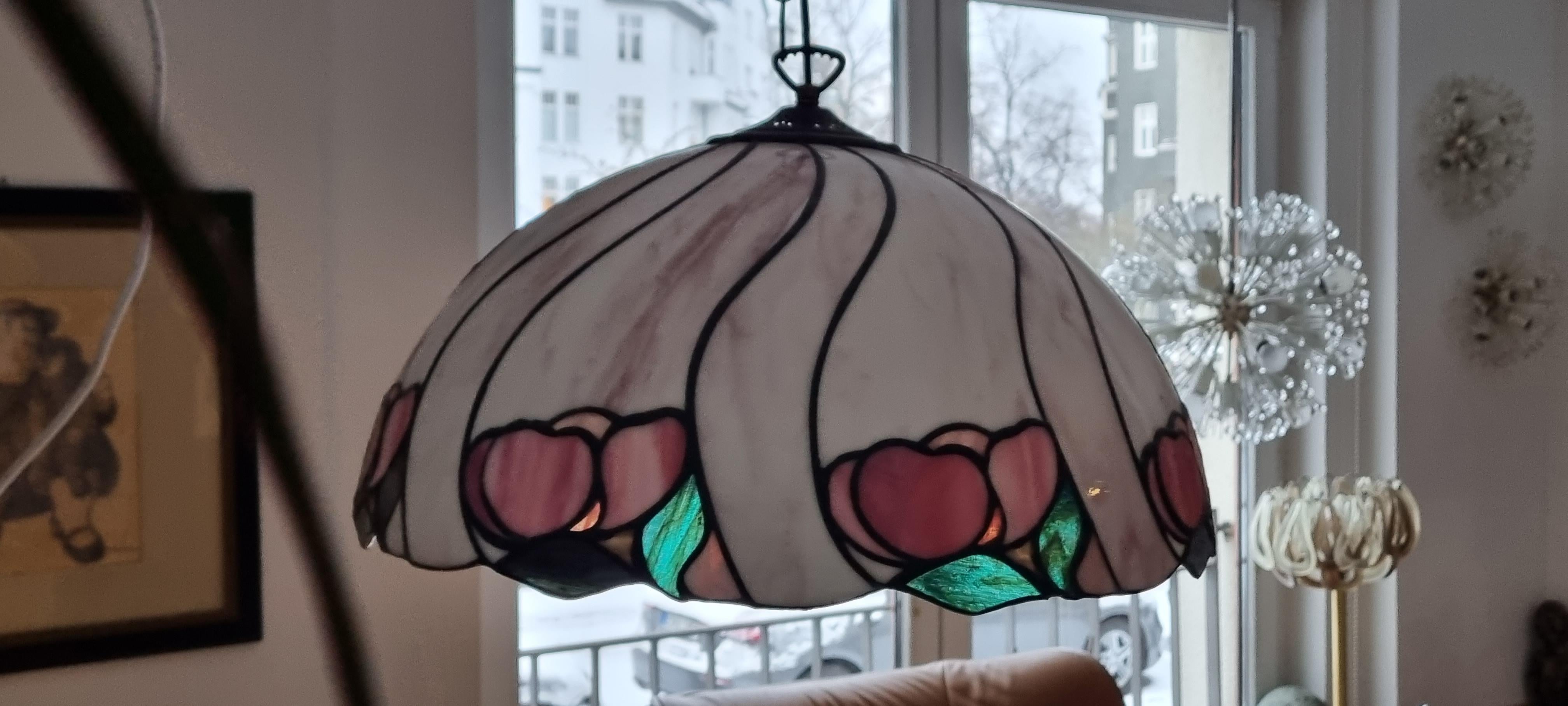 Handmade hanging lamp made of Tiffany glass with holder, chain and ceiling canopy made of patinated brass. E 27 bulb is needed.

Very nice condition, no damages.