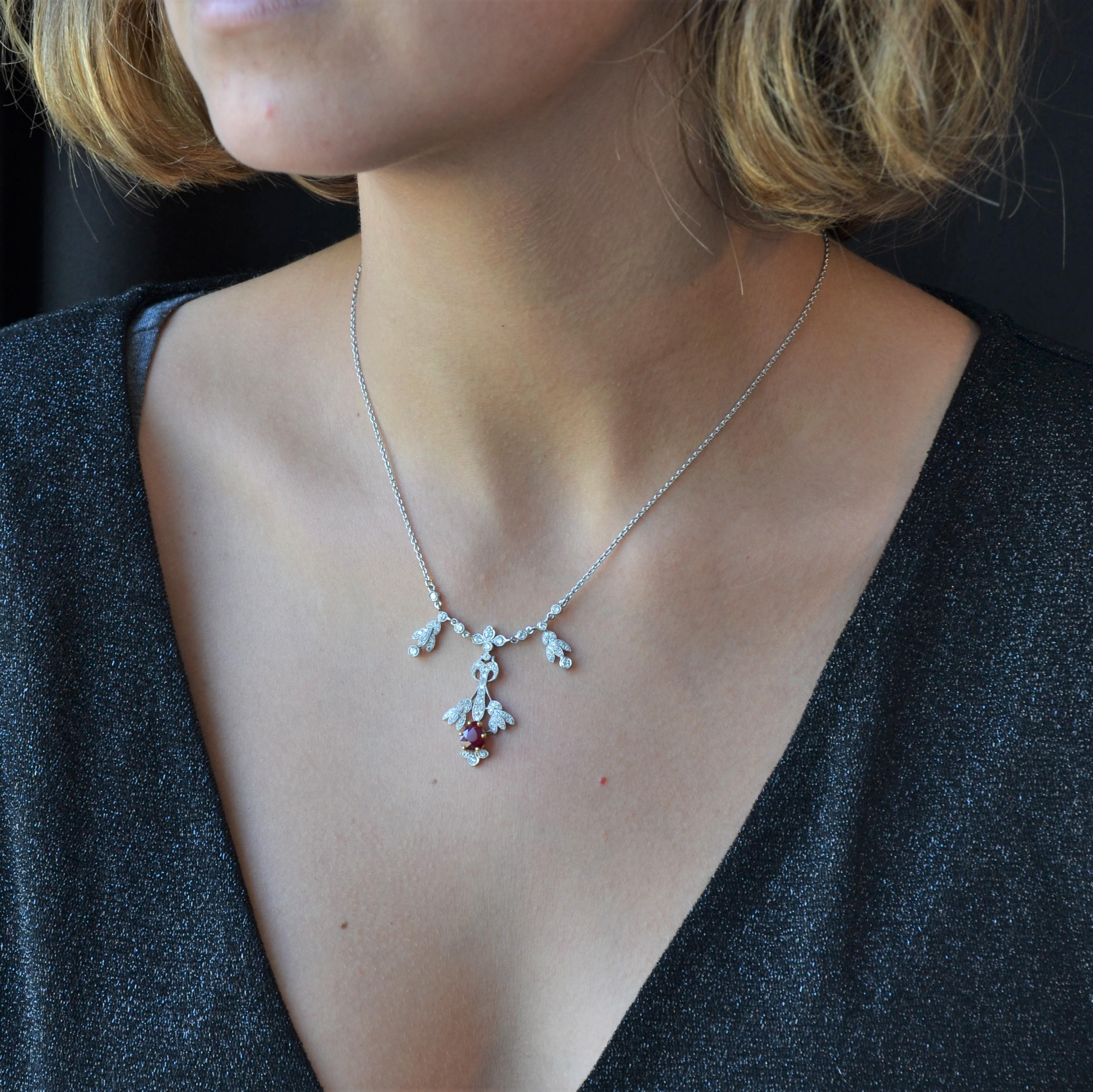 Collar de platino y oro de 18 quilates, sello de cabeza de águila y platino.
Esta encantadora joya consta de un motivo central de líneas vegetales totalmente engastado con diamantes talla brillante y en el centro un rubí talla pera. A ambos lados de