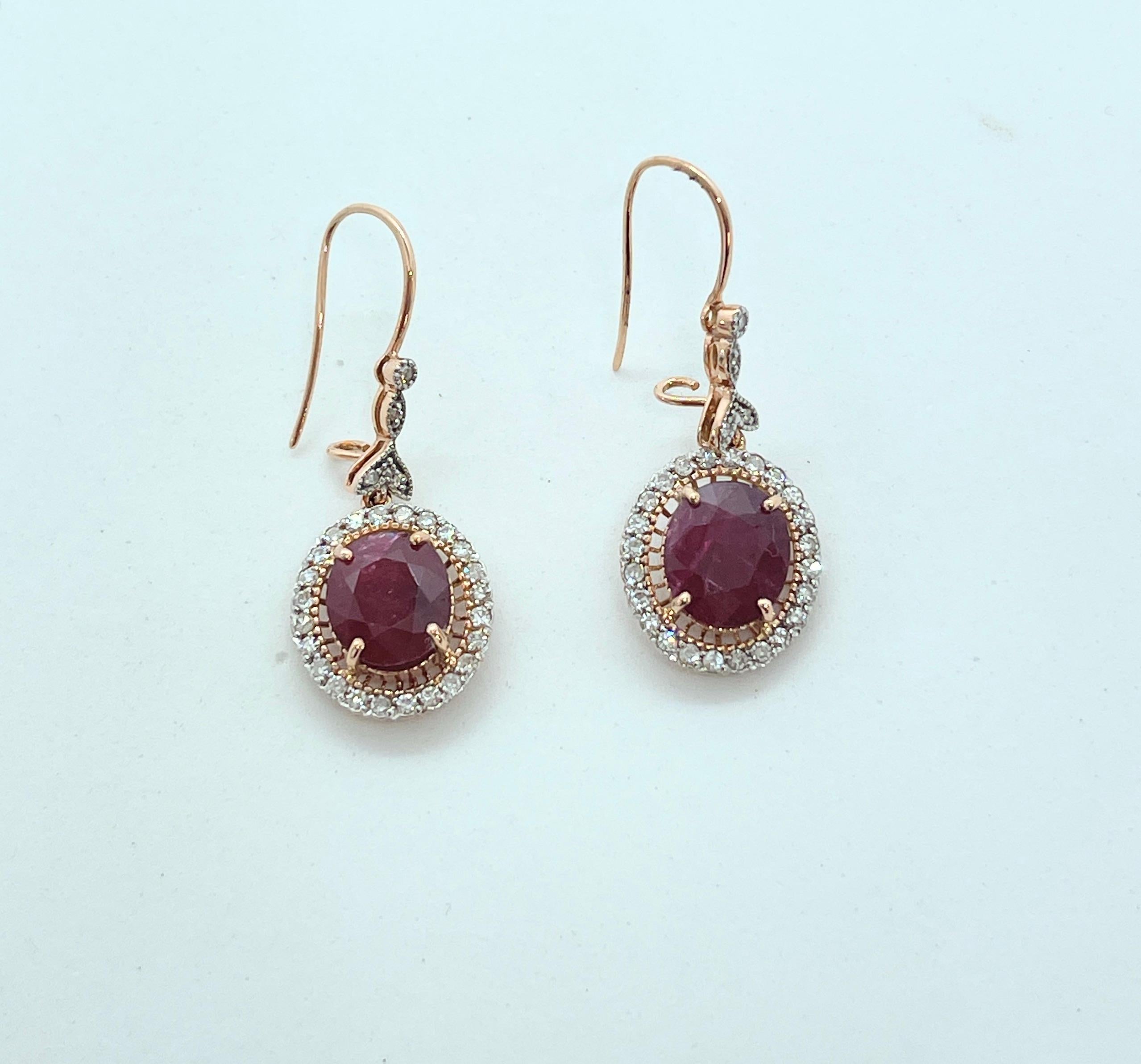 Stylish and elegant, these earrings feature Oval shaped Rubies surrounded with genuine, earth mined Diamonds. The earrings are set in 14ct rose gold and dangle on shepherd hooks with a safety hook to the rear.  They are a nice size that would be