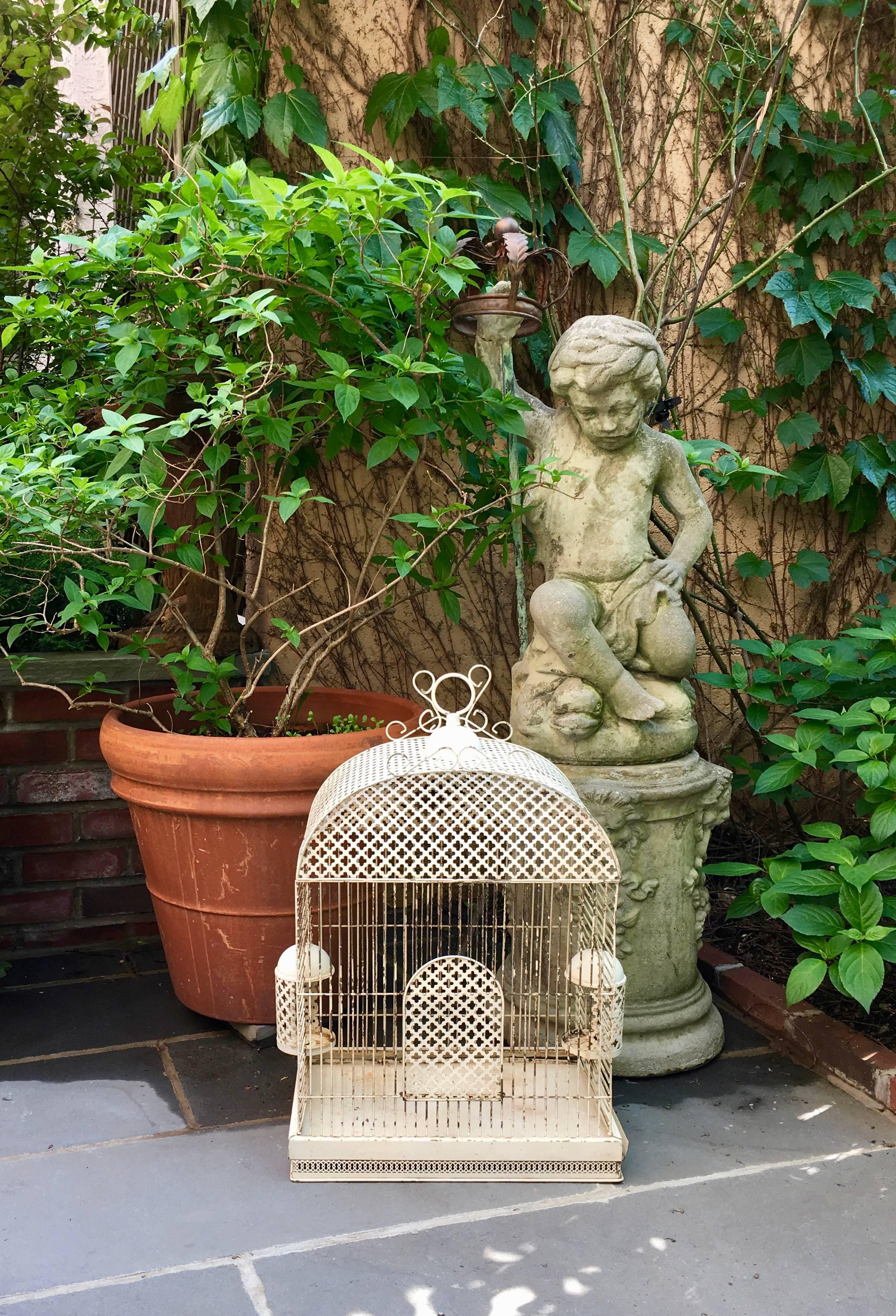 A charming, Belle Époque, French Tôle Peinte bird cage, circa 1871-1914. The creamy-white painted metal cage is large enough for a pair of love birds. 

The bottom tray slides out completely for cleaning and there are two feeders that swing out