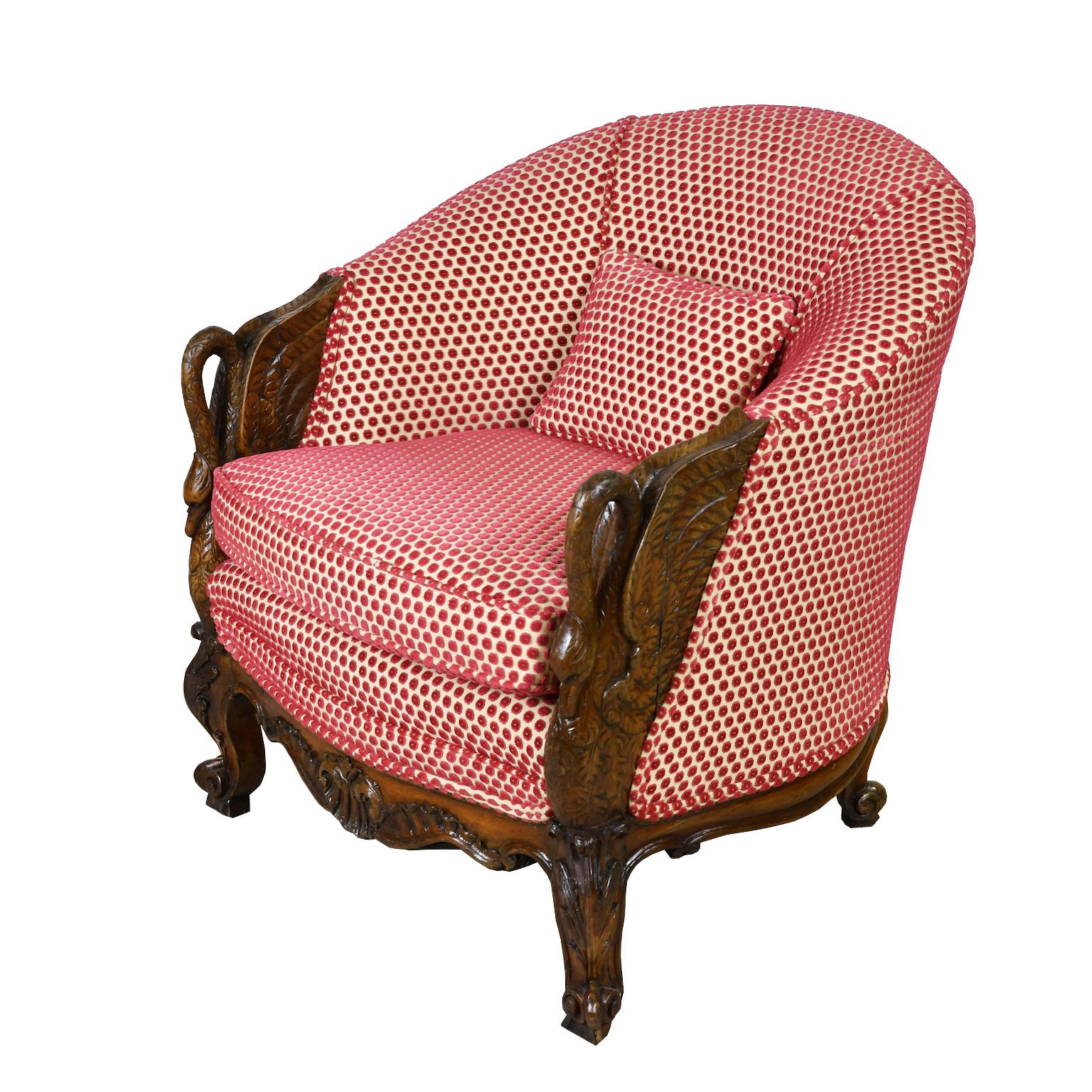 A very beautiful club chair with gondola form featuring finely carved arms in the shape of swans with tucked head and outstretched wings. Chair rests on acanthus-carved scroll feet with rocaille-work on apron. Upholstered in a fine rose polka-dot,