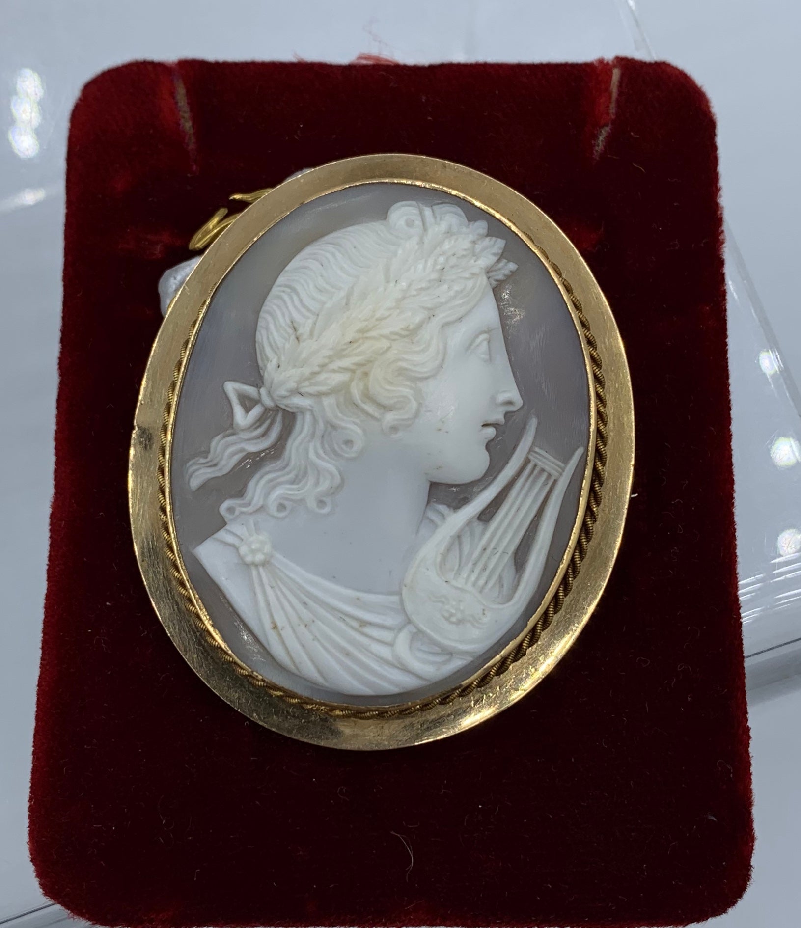 This is an absolutely stunning large size antique Victorian - Belle Epoque Shell Cameo Brooch Pin with a high relief carving of a neoclassical image of the God Apollo with a lyre instrument and a laurel wreath in his hair.  The cameo is of