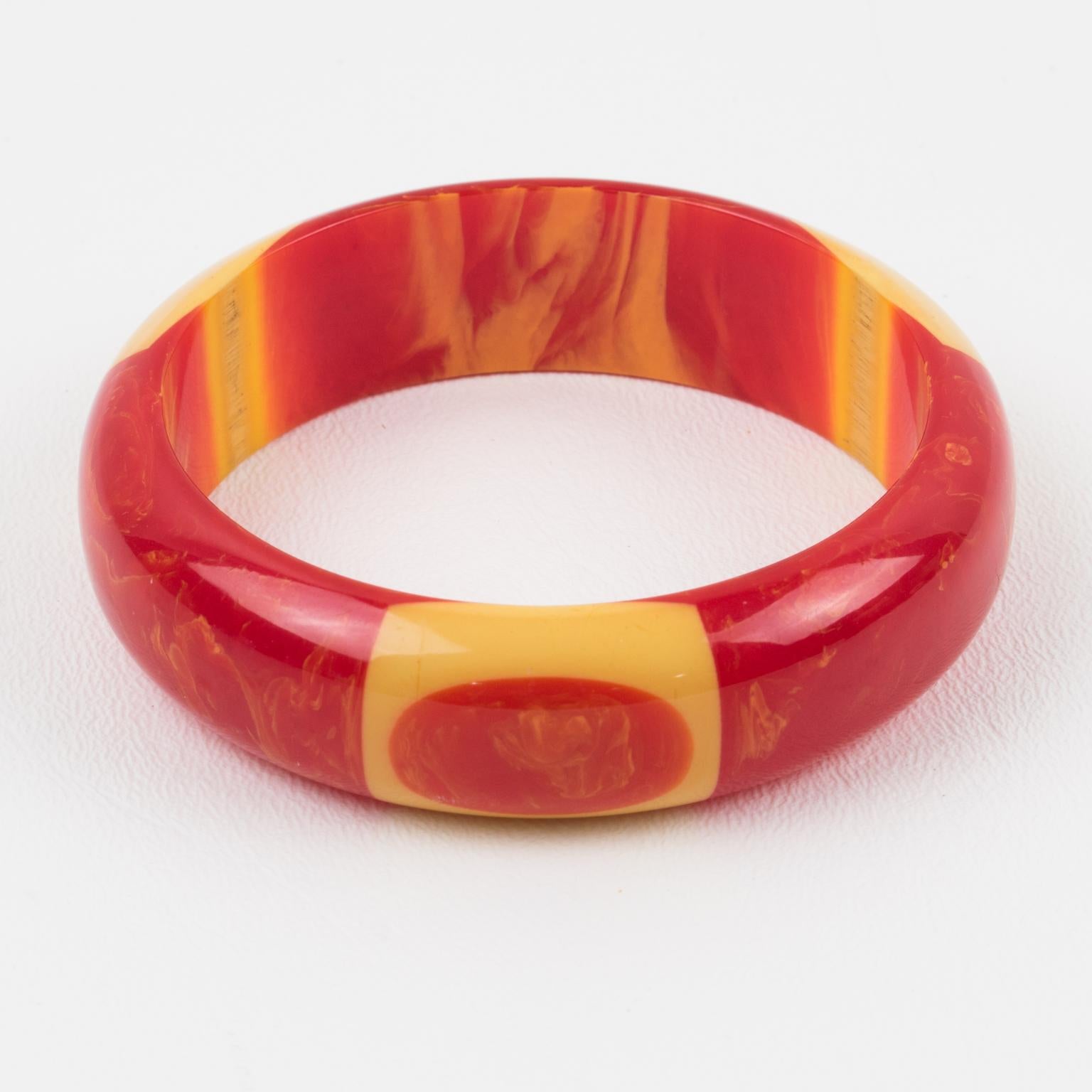 This outstanding Belle Kogan Bakelite elongated inlay dot bracelet bangle is a must-have in a Bakelite collection. The dots are set with yellow banana surrounds in a cheesy red marble color and appear three times around the bangle. The bracelet has