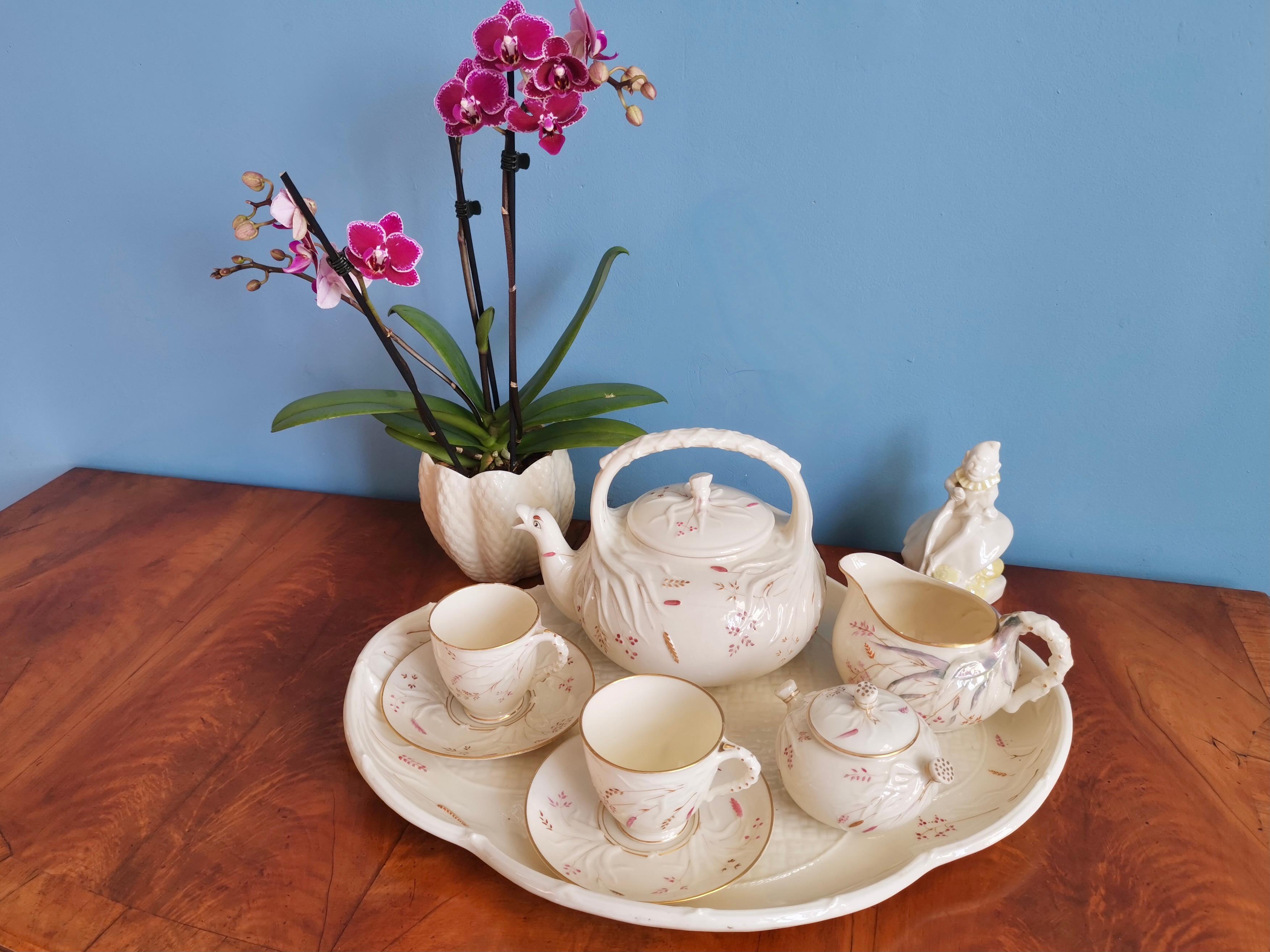 This is a beautiful and very rare Belleek cabaret set in the Grass design, consisting of a teapot, two teacups and saucers, a milk jug and a lidded sugar bowl, all placed on a large tray. All items carry the 1st Black Mark, which was used between