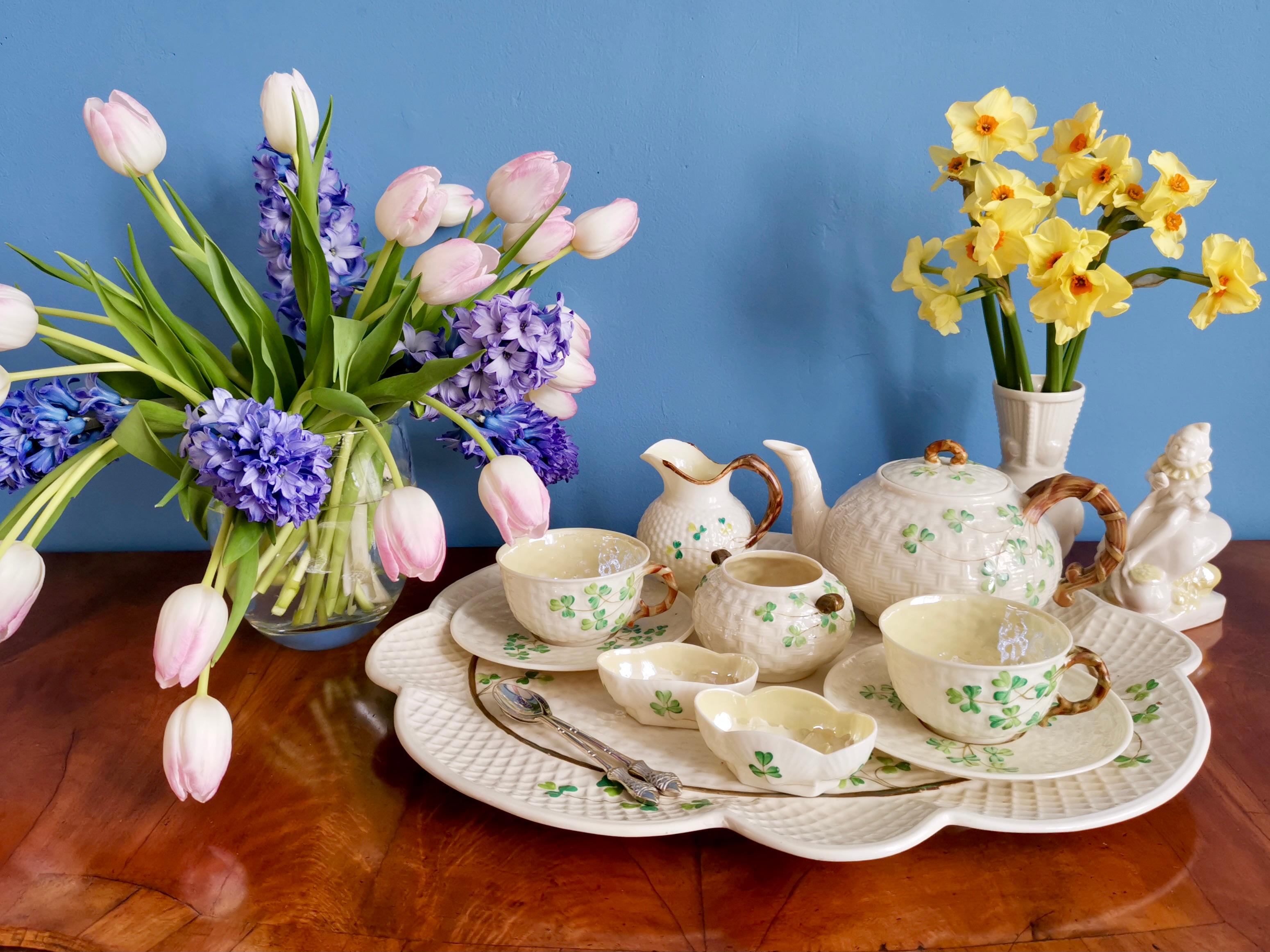 This is a rare and gorgeous Belleek cabaret tea service, or dejeuner set, in the famous Shamrock design, consisting of a teapot, two teacups and saucers, a milk jug, a sugar bowl, and a salt and pepper, all placed on a large matching tray. 

It is