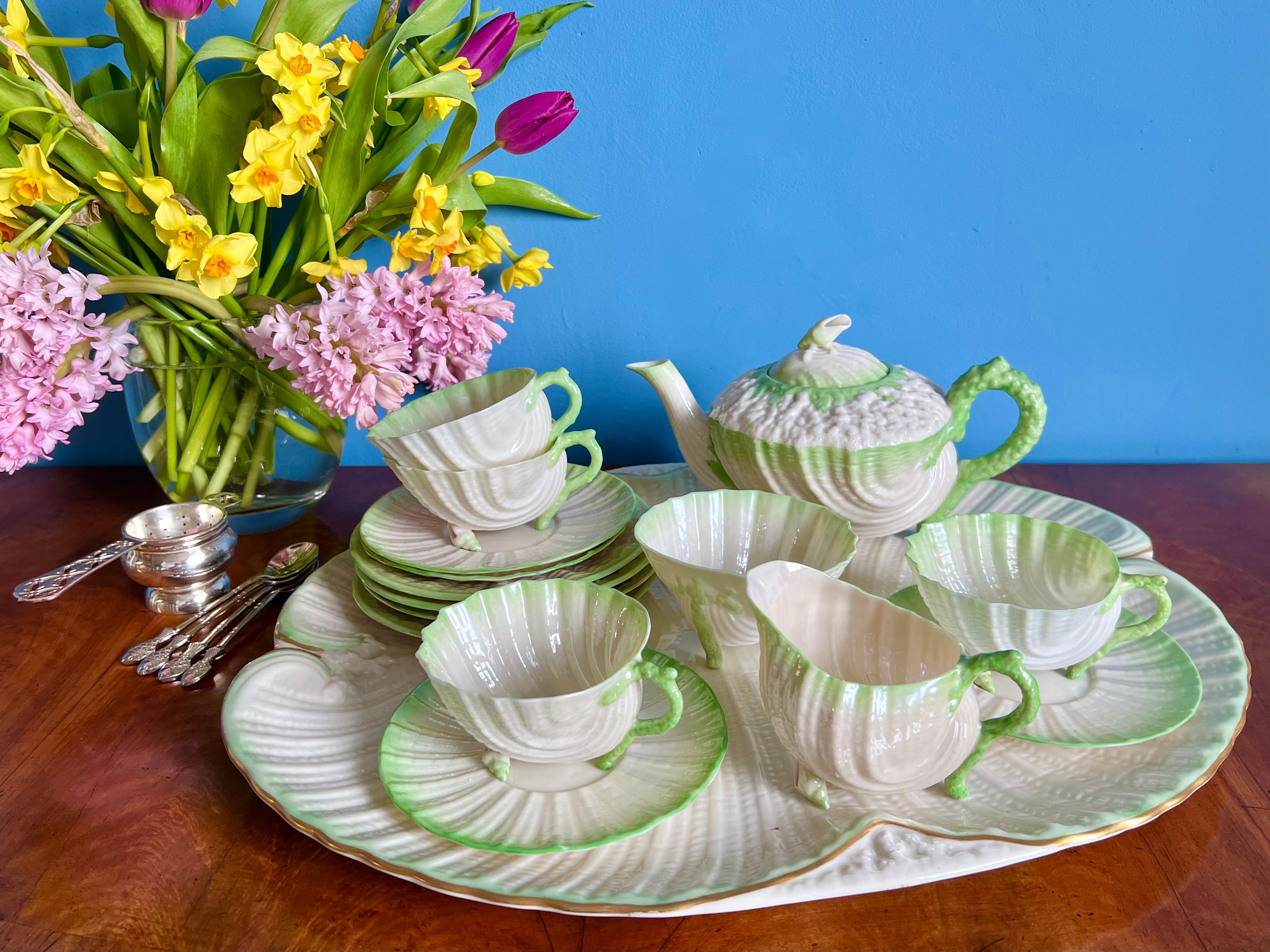 This is a rare and gorgeous Belleek cabaret tea service for four in the green Neptune design made by Belleek. The various pieces were made between 1863 and 1926, with most of them between 1891 and 1946. The service consists of a teapot, four