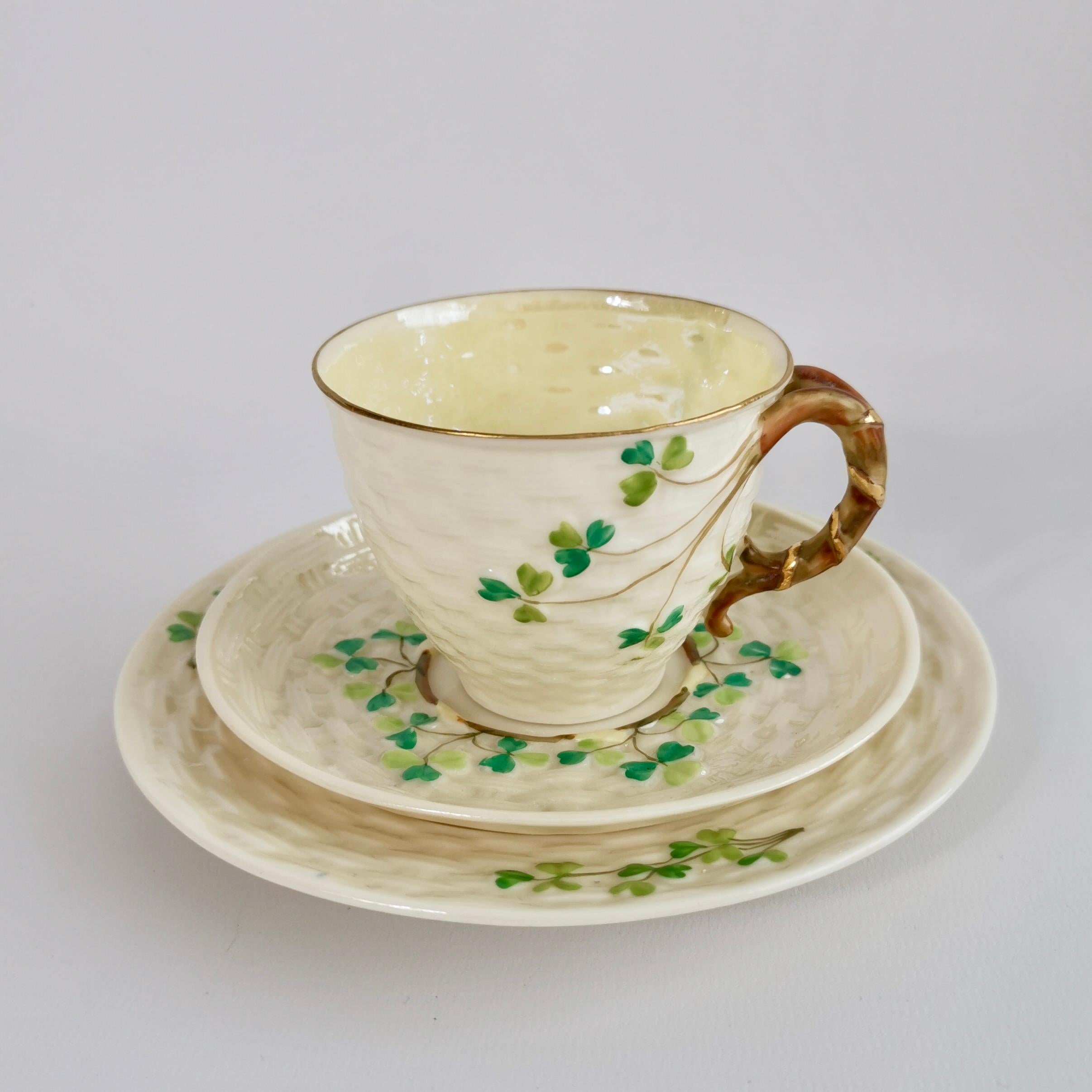 This is a very charming coffee cup trio made by Belleek in the Shamrock design, consisting of a coffee cup, a saucer and a little cake plate. It has the 2nd Black Mark, which was used between 1891 and 1926. Given the quality of the porcelain we